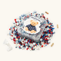 Americana Bead Kit flat-lay of red, white, and blue beads, crystals, and letter blocks spread out on a white background