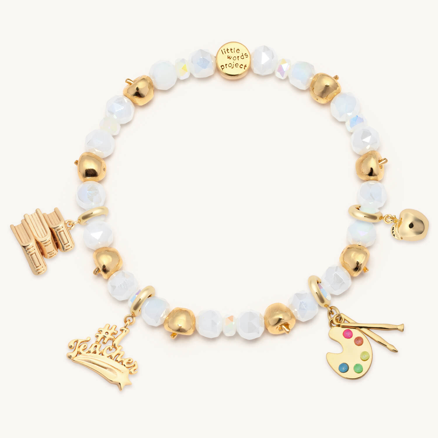 Bracelet with gold and white beads and various charms on a white background