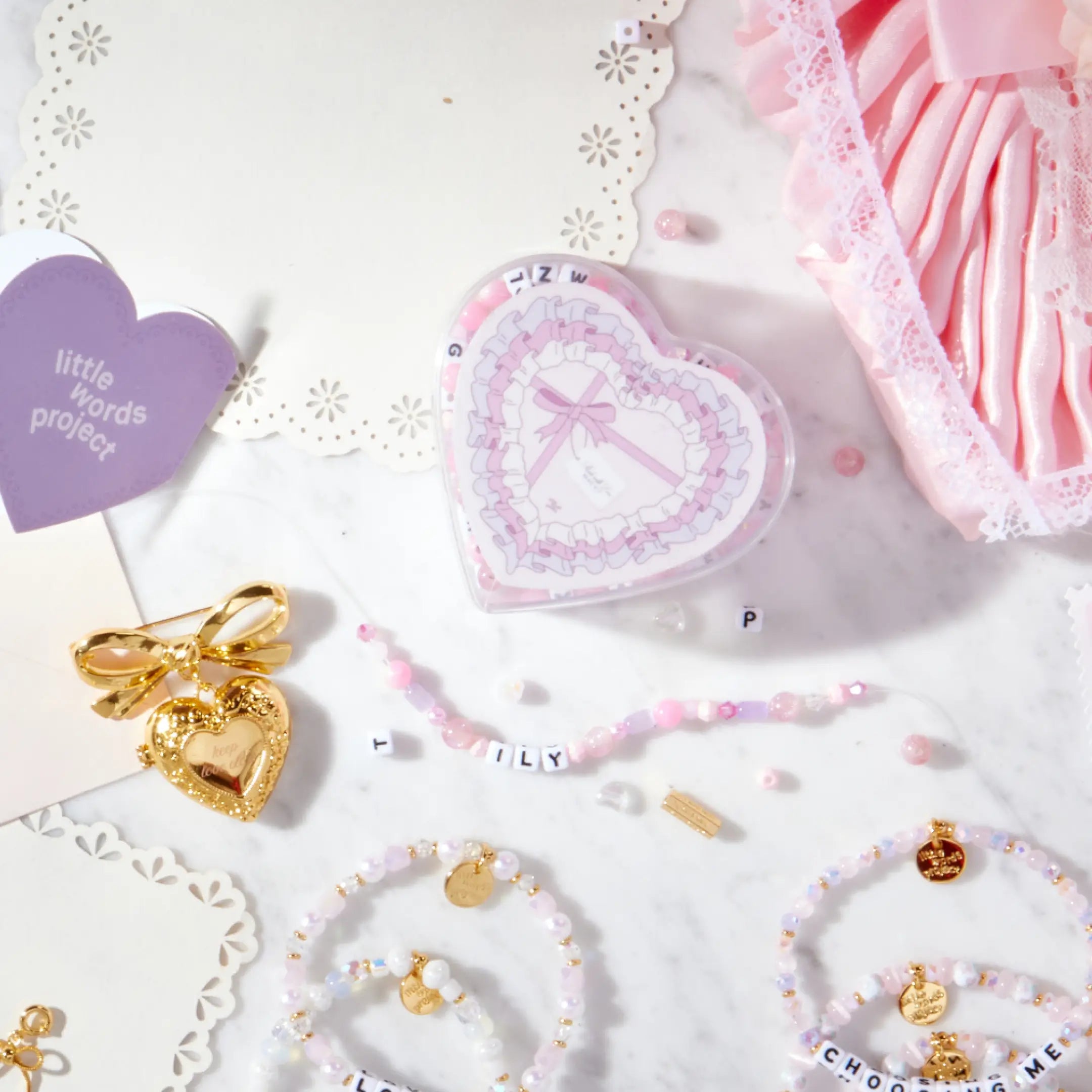 Jewelry set with heart-shaped box and decorative items on a white background