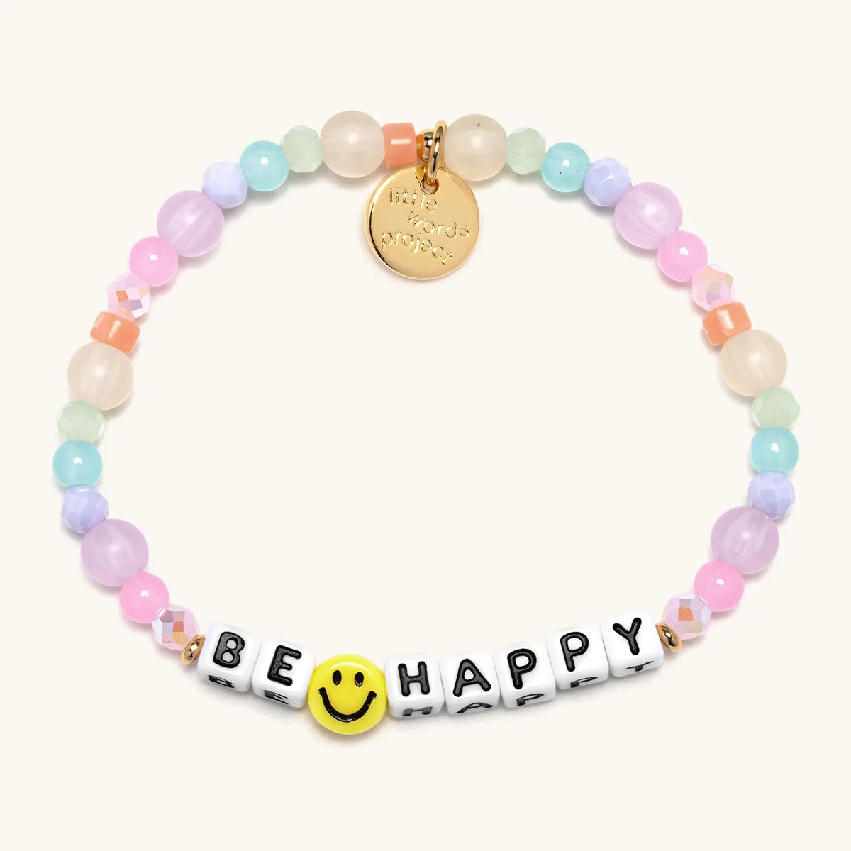 Be Happy bracelet with white letter beads from the Good as Gold Bracelet Set, flat-lay on cream background