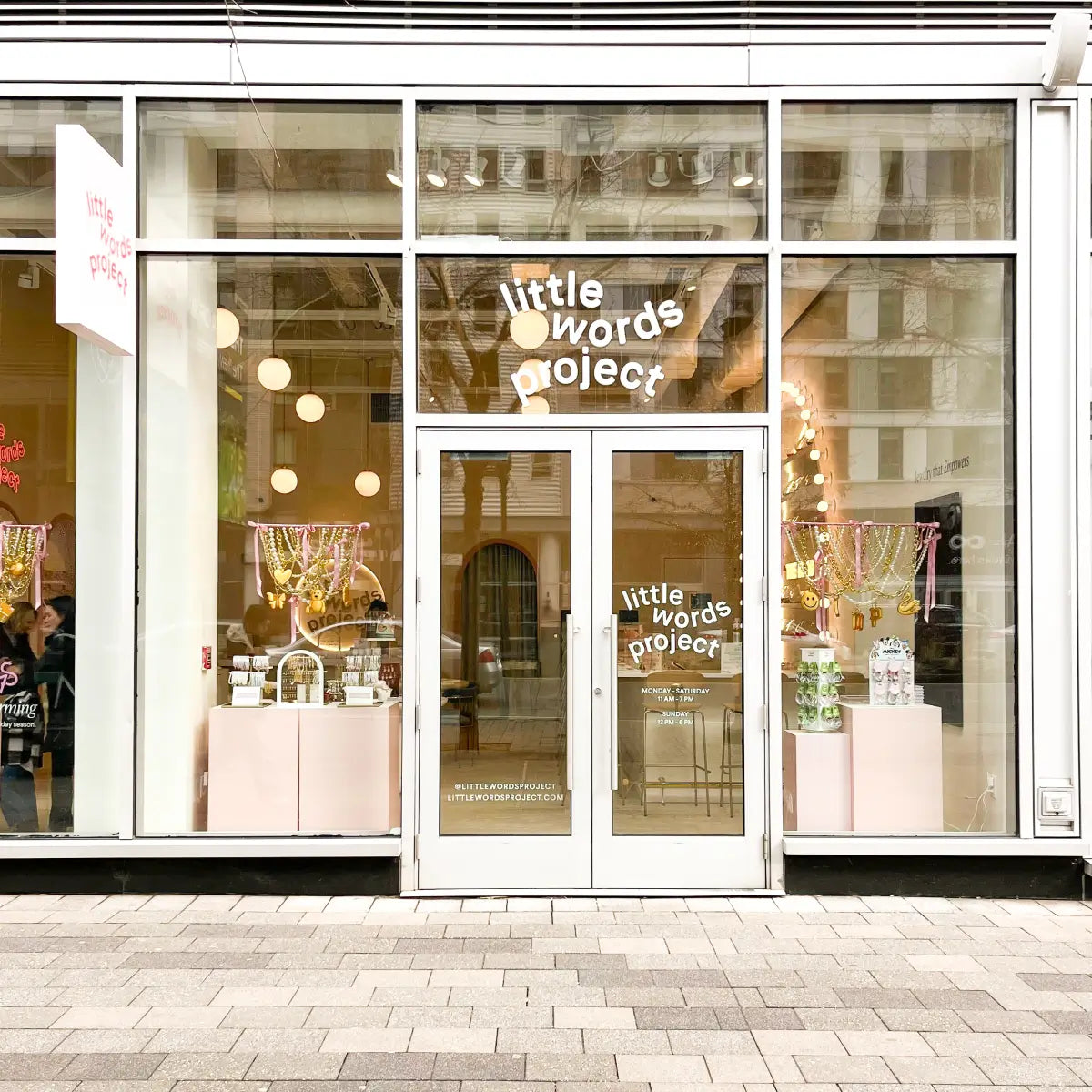 Storefront with 'little words project' branding on glass doors and windows.