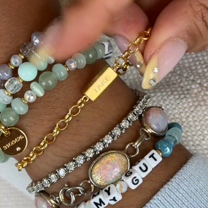 Gold curb chain bracelet by Little Words Project with a spinning "JUST / TAKE" bar charm, designed to spin.