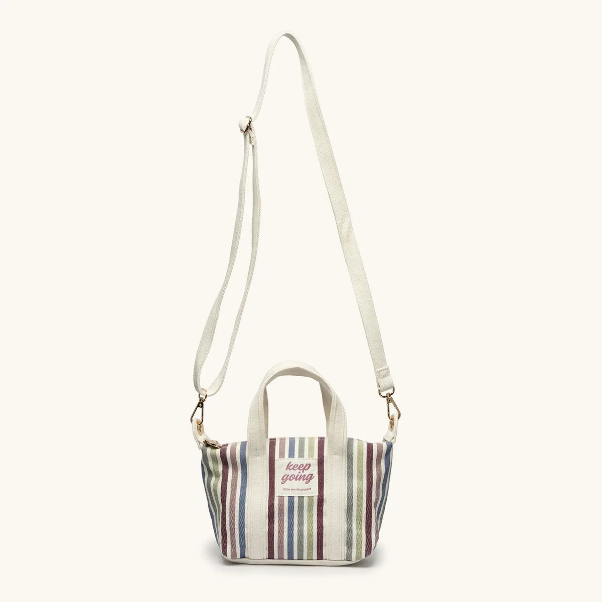 Keep Going Mini Tote front view, striped natural canvas with cream double handles and gold strap rings, flat-lay on cream background