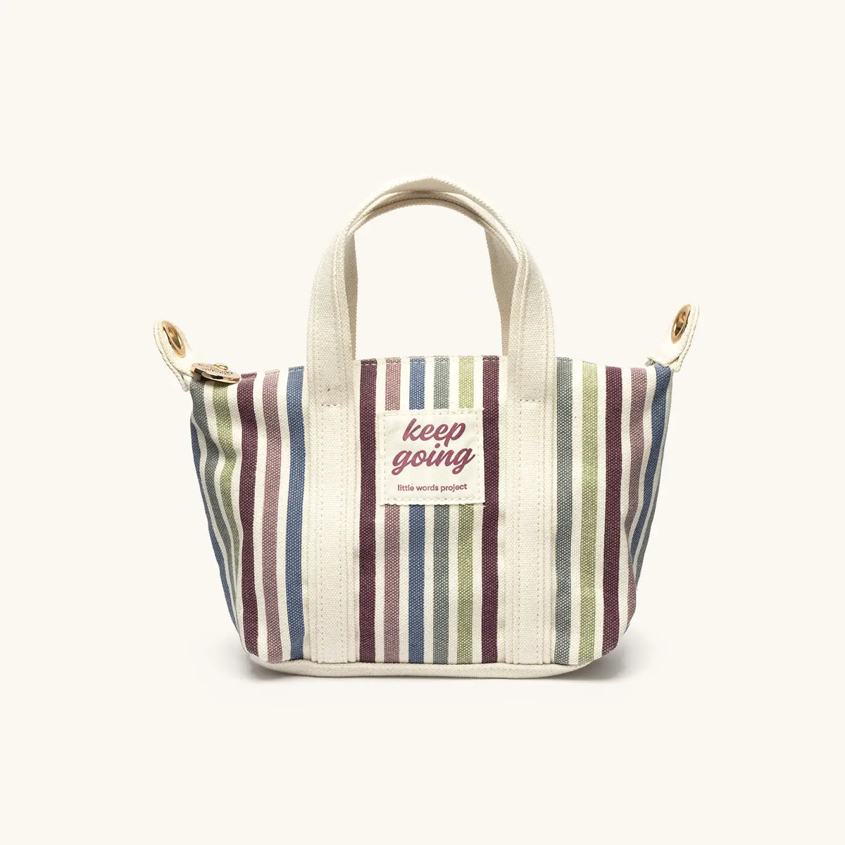 Keep Going Mini Tote with the removable, adjustable cream shoulder strap attached, on cream background
