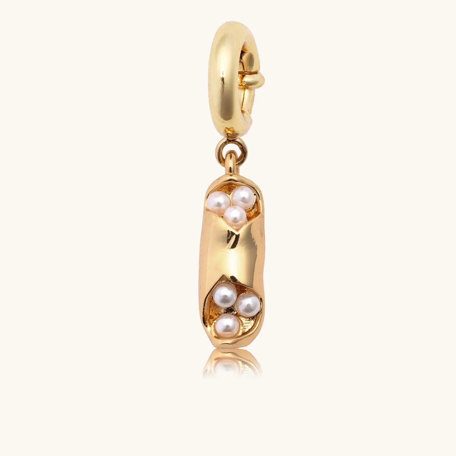 Gold charm with pearls on a white background