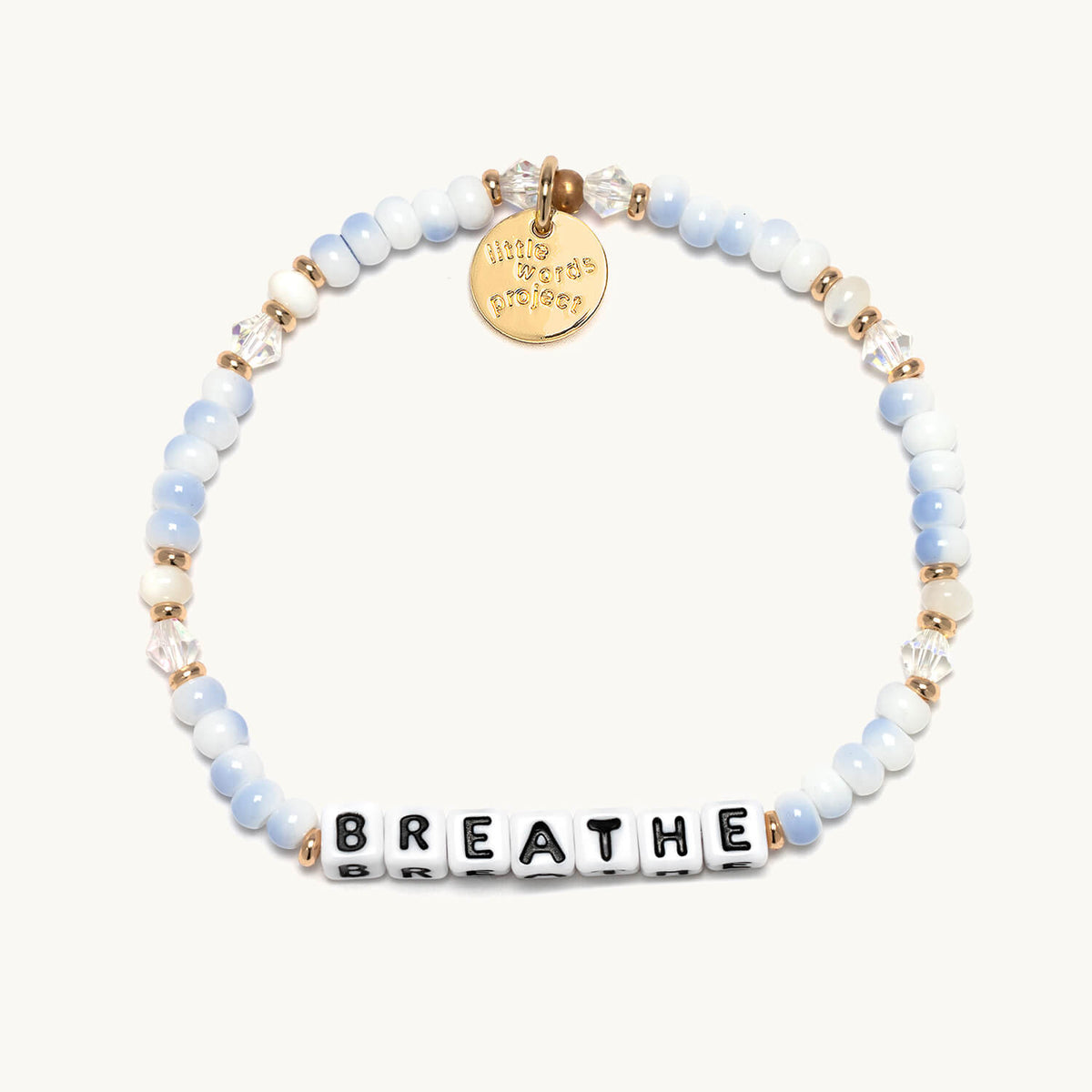 Breathe bracelet with white letter beads from the Soft & Strong Bracelet Set, flat-lay on cream background