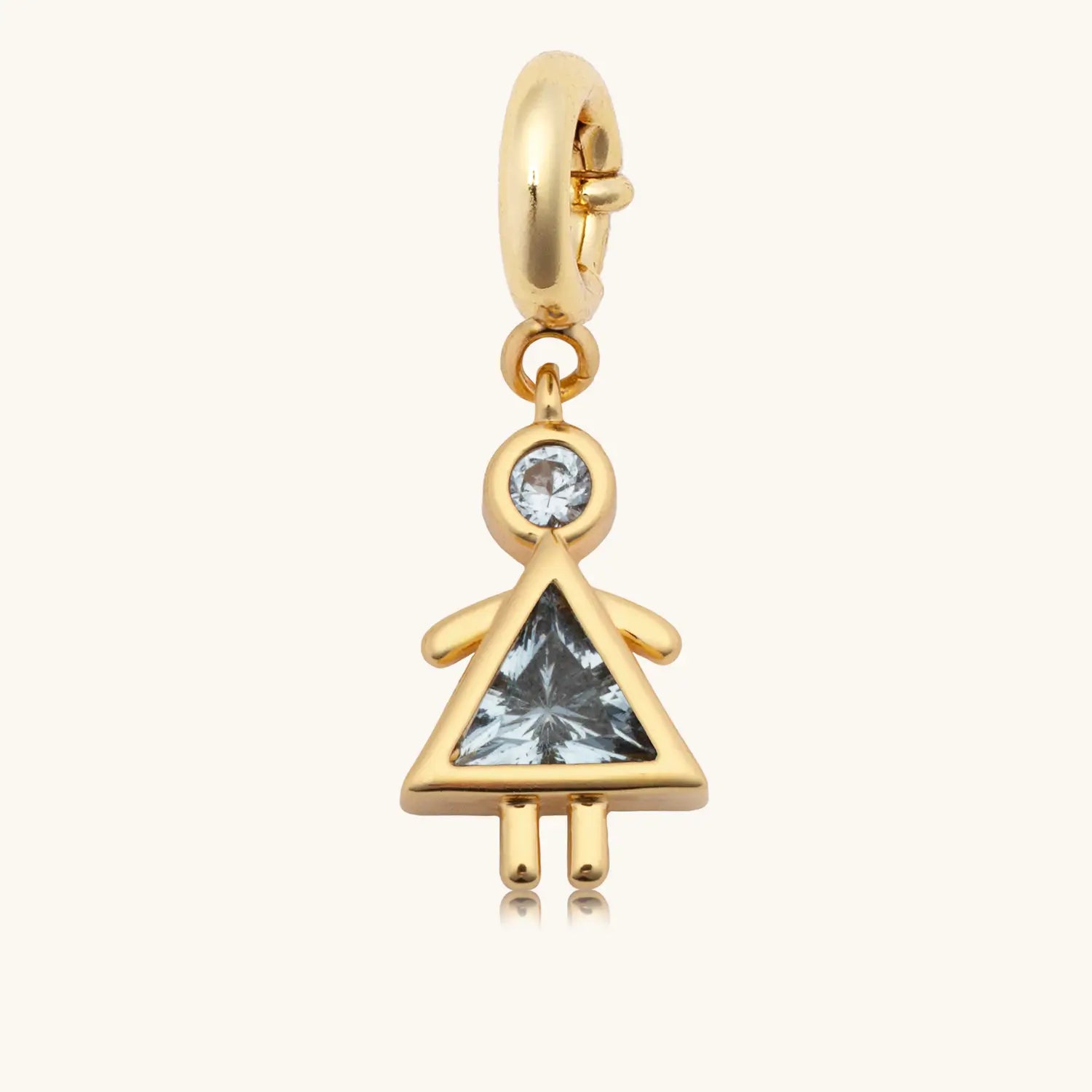 Gold charm with a blue gemstone on a white background
