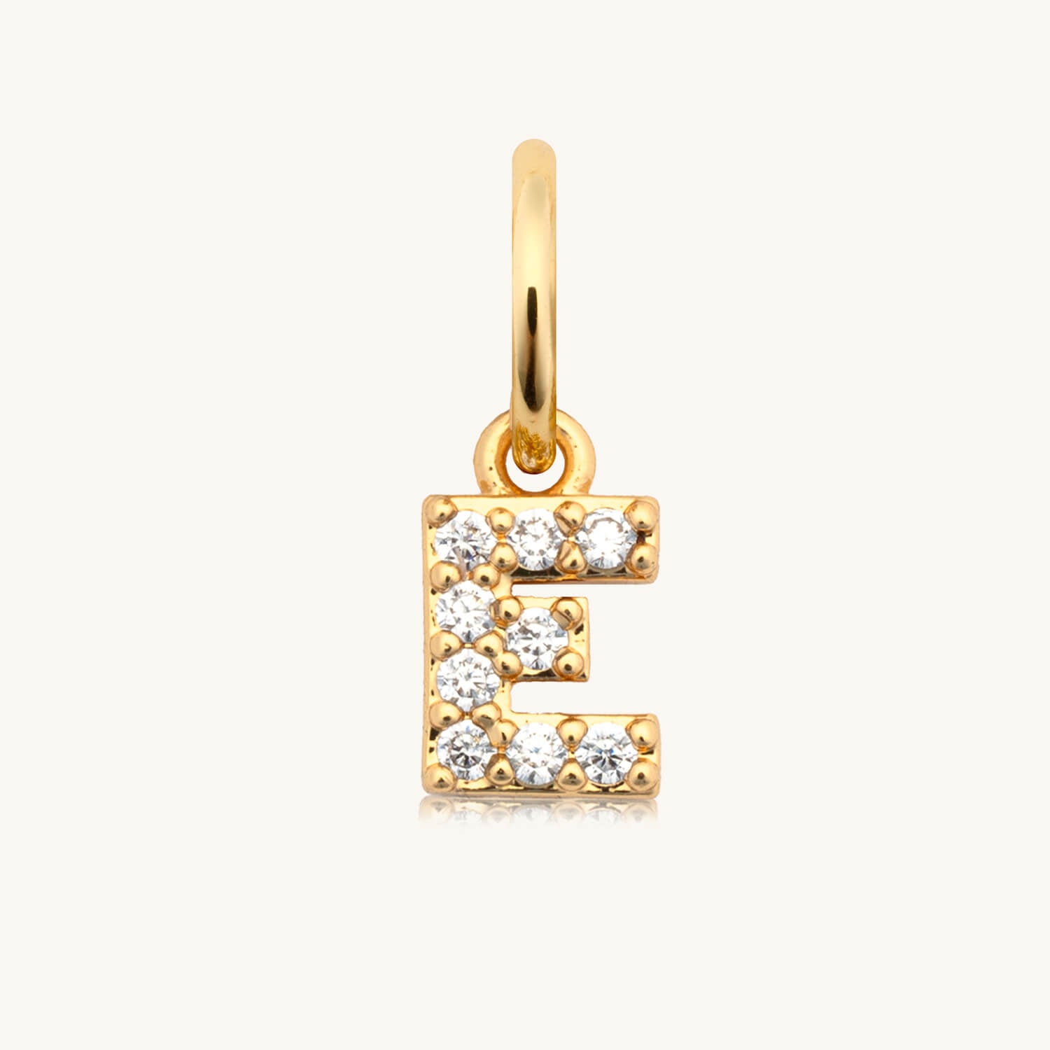Gold pendant with the letter 'E' on a white background