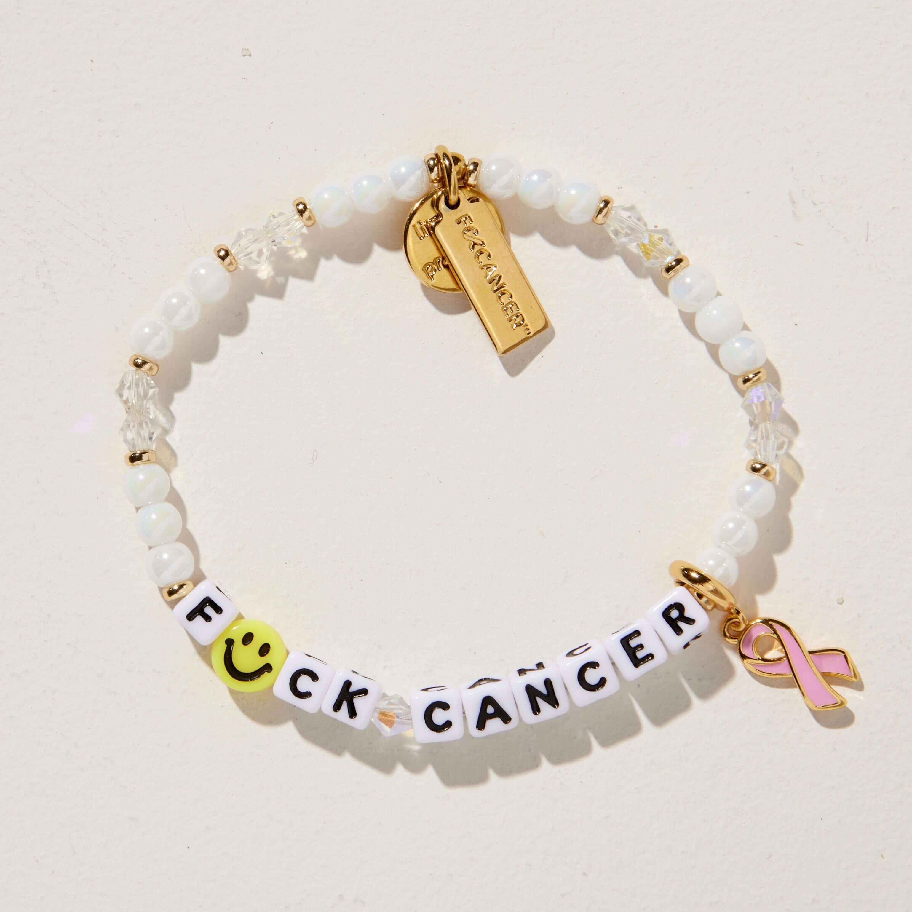 Bracelet with 'F*ck Cancer' charm and pink ribbon on a light background