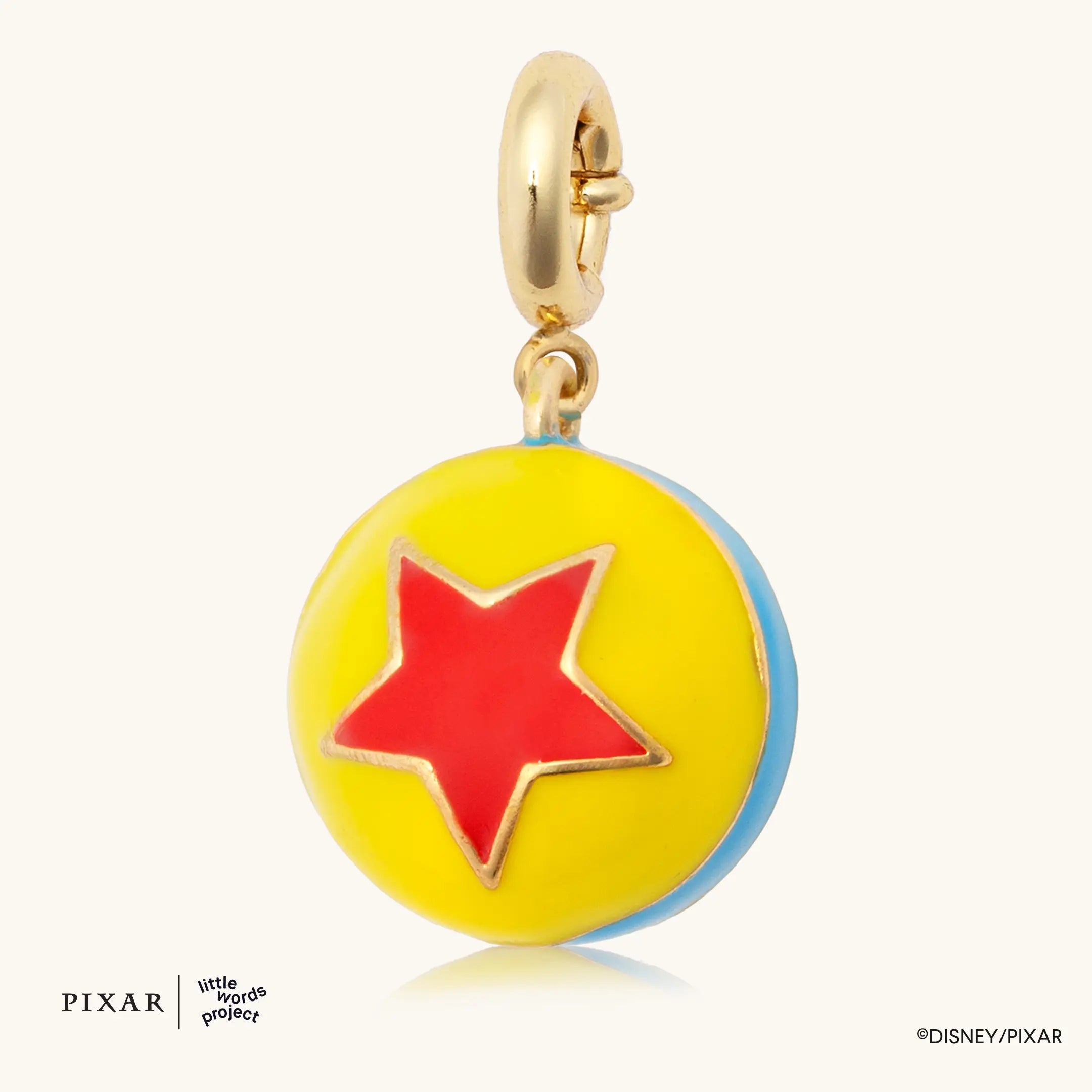 Pixar Ball Charm, gold Toy Story charm of the yellow Pixar ball with a red star, flat lay