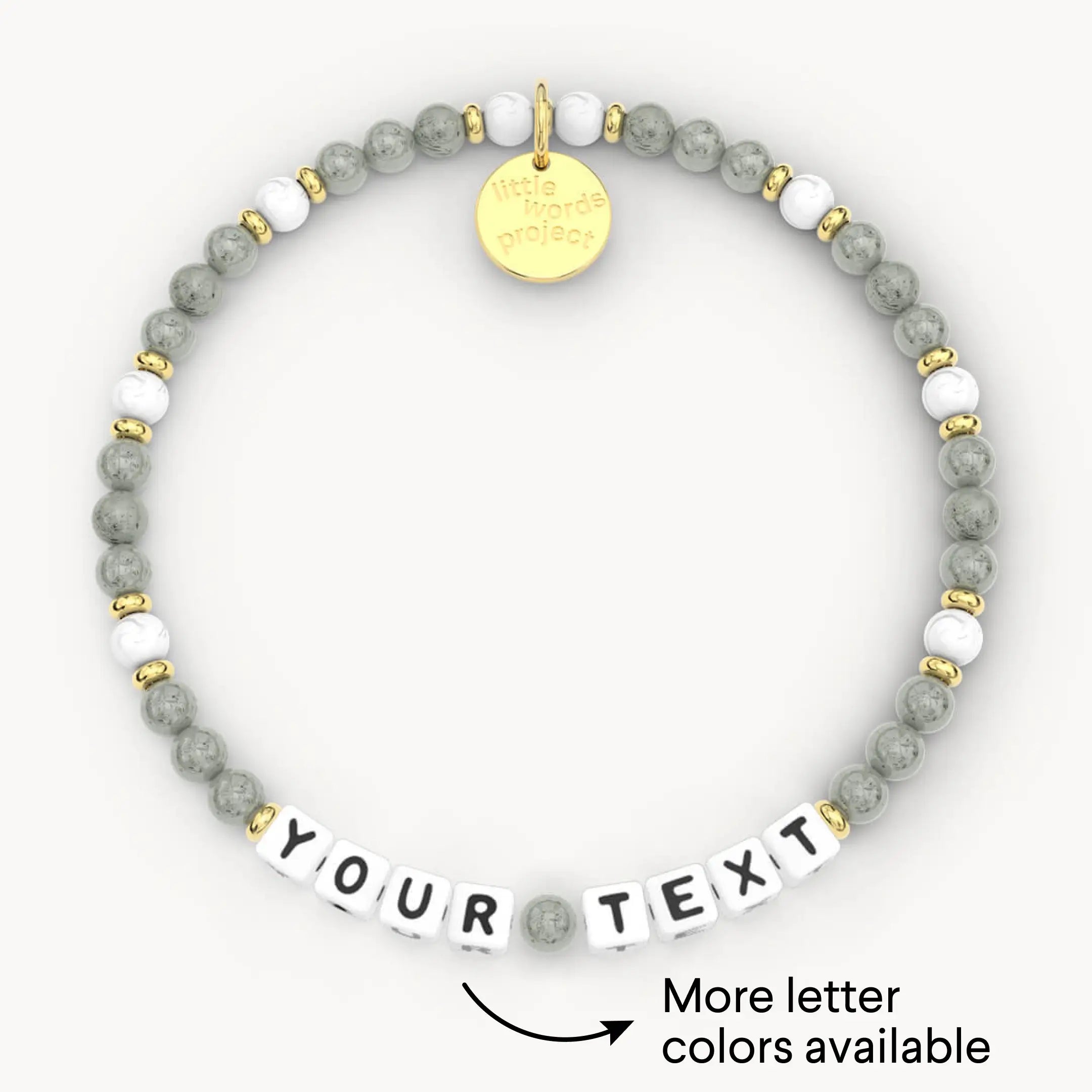 Bracelet with gray beads, gold accents, and customizable letter tiles on a white background