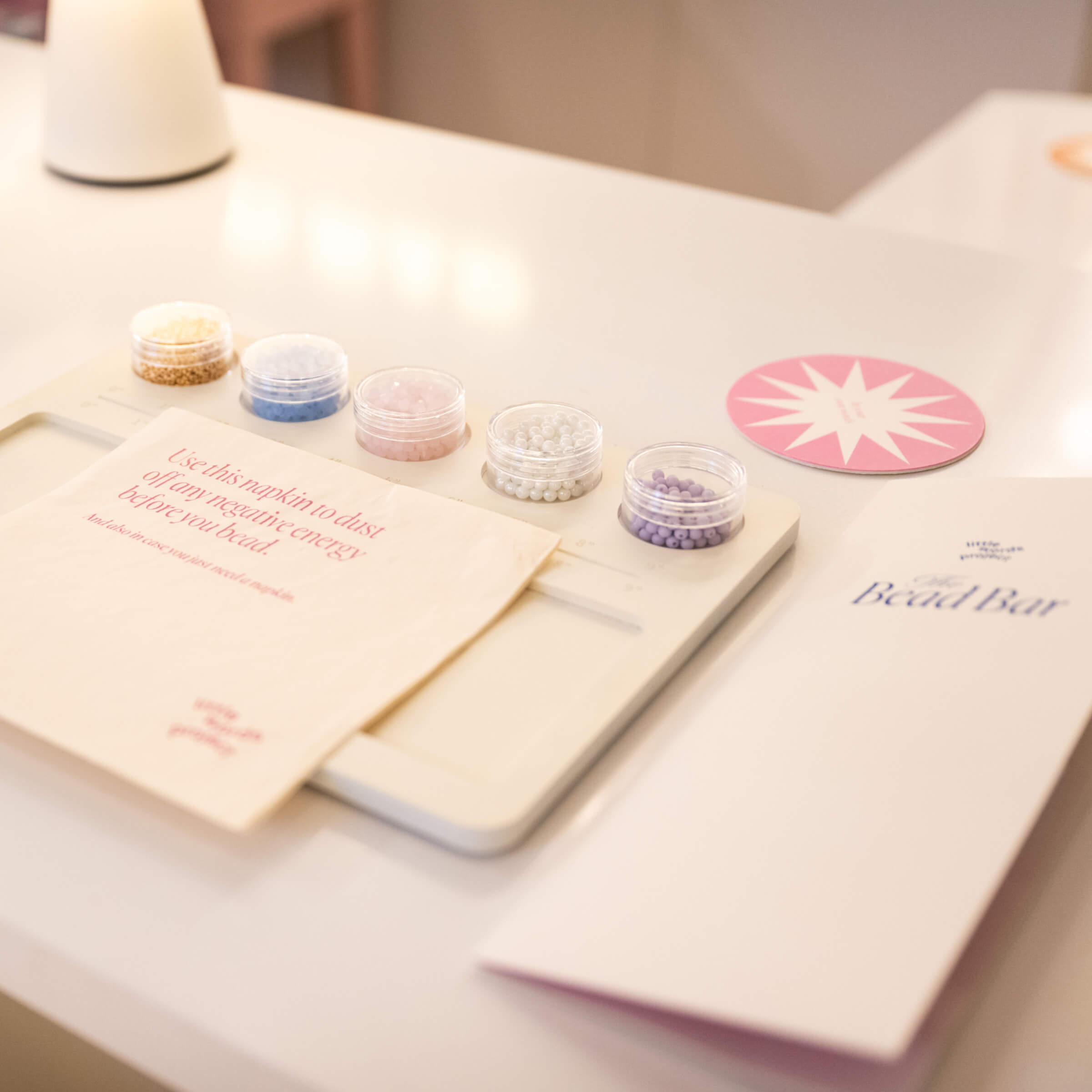 Bead bar kit with containers and cards on a white surface