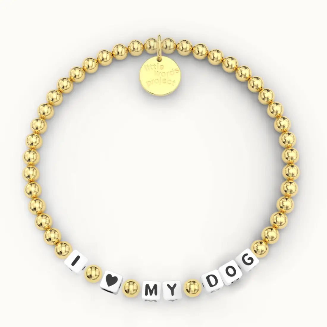 I <3 My Dog giveback bracelet in the Gold Plated bead pattern, white letter beads with a black heart and gold plated beads, flat-lay on cream background