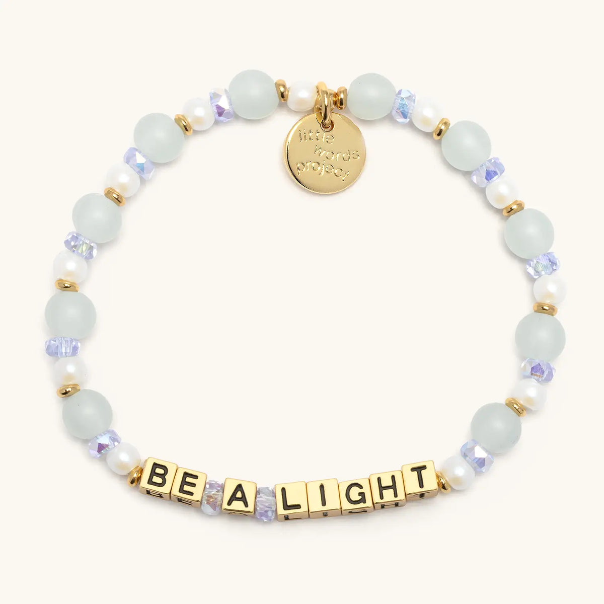 Be a Light bracelet with gold letter beads from the Good as Gold Bracelet Set, flat-lay on cream background