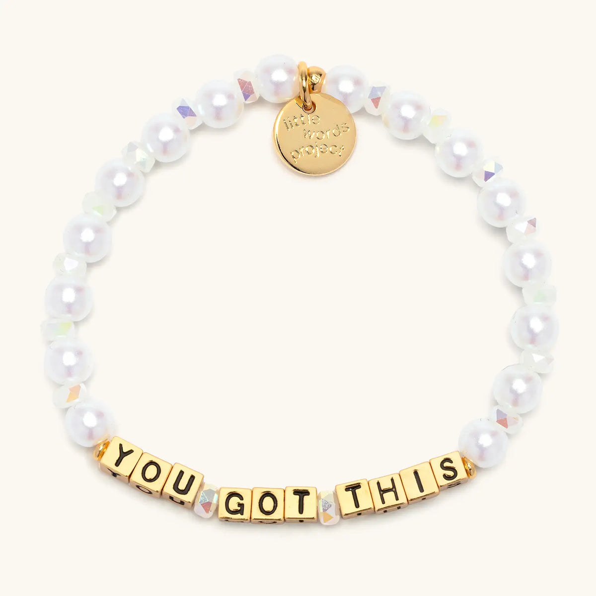 Gold You Got This bracelet in the Cloud Crush bead pattern, gold letter beads with white faux pearls and iridescent crystals with gold accents, flat-lay on cream background