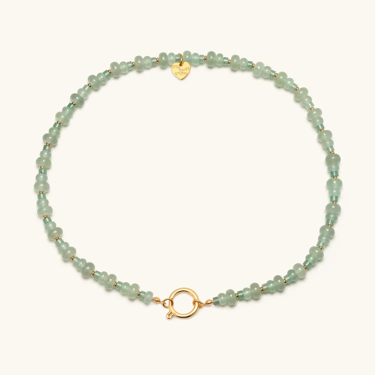Green beaded bracelet with gold clasp on a white background