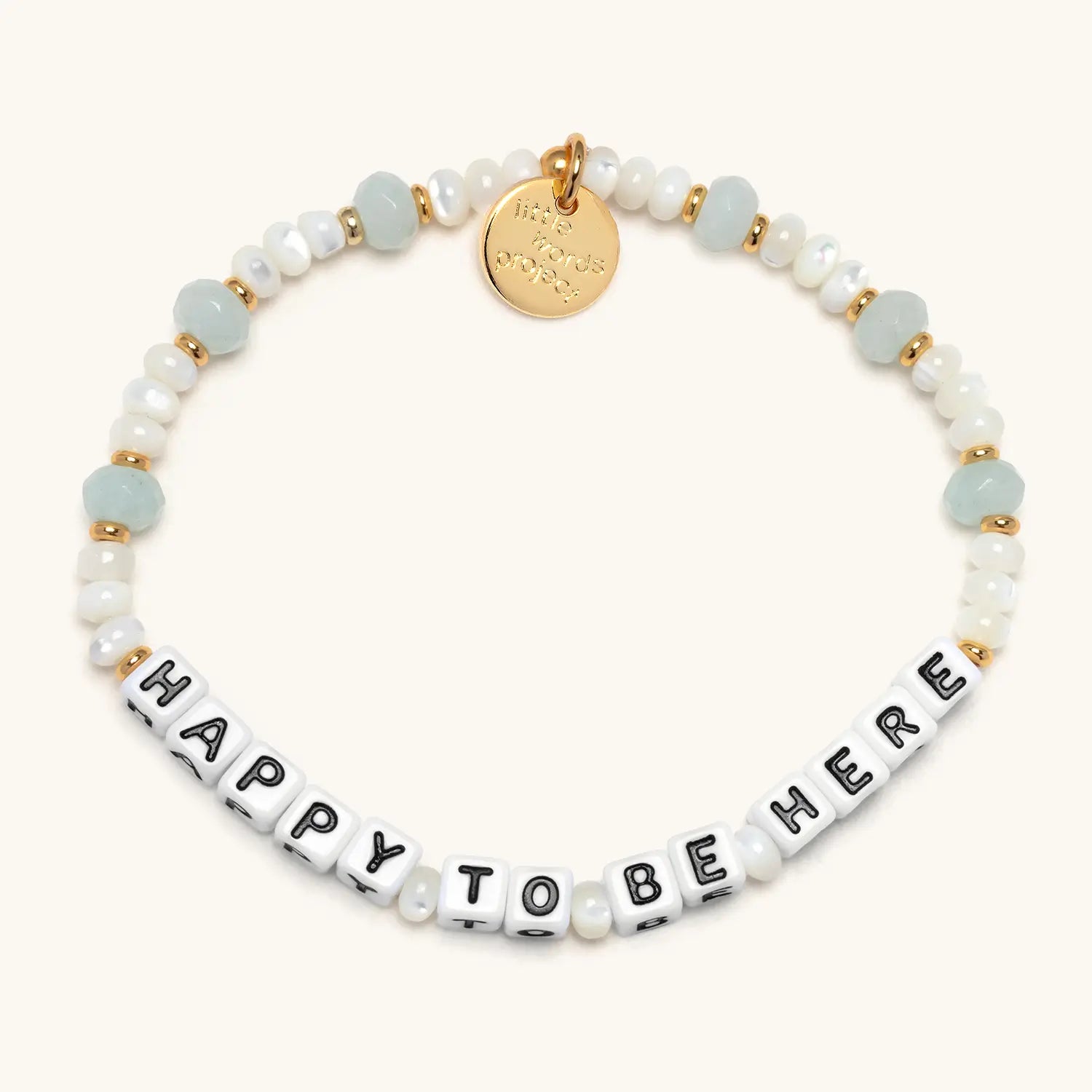 Bracelet with 'Happy to be here' beads and gold tag on a white background