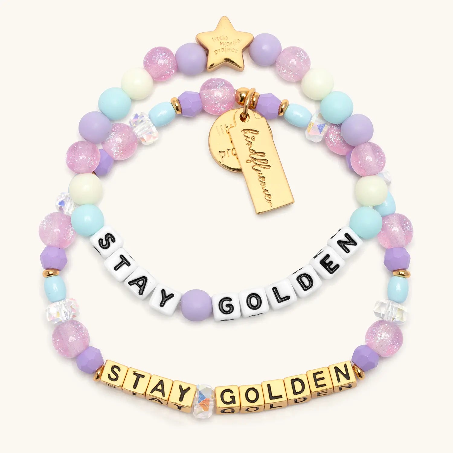 Stay Golden Bracelet Set Rylee Ta with adult bracelet in gold letter beads and kids bracelet in white letter beads, lavender crystal, light blue and cream beads with gold star charms, flat lay