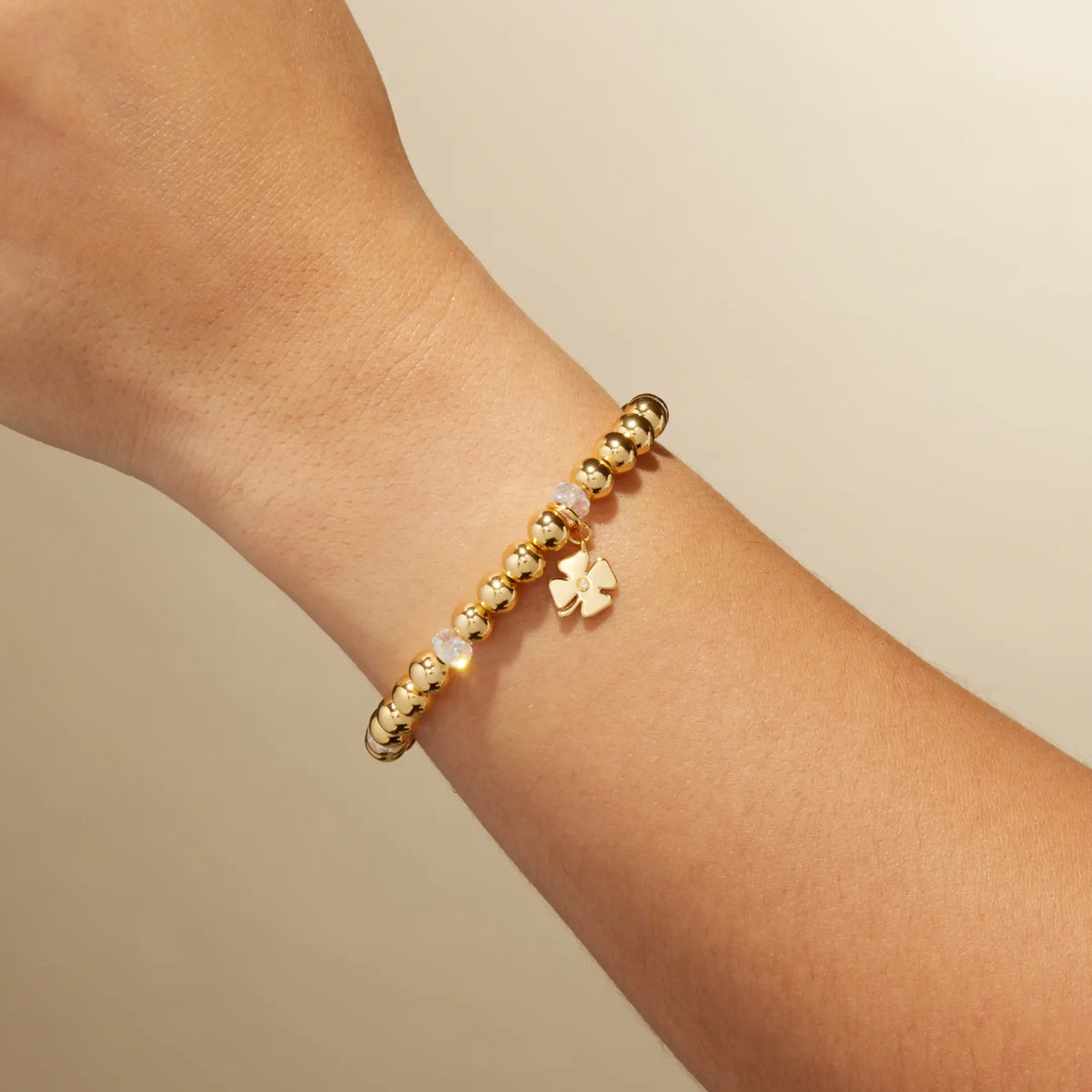 Four Leaf Clover Charm Bracelet by Kirstin Czernek on-model on wrist, gold plated beads with clear crystals and a gold four leaf clover charm