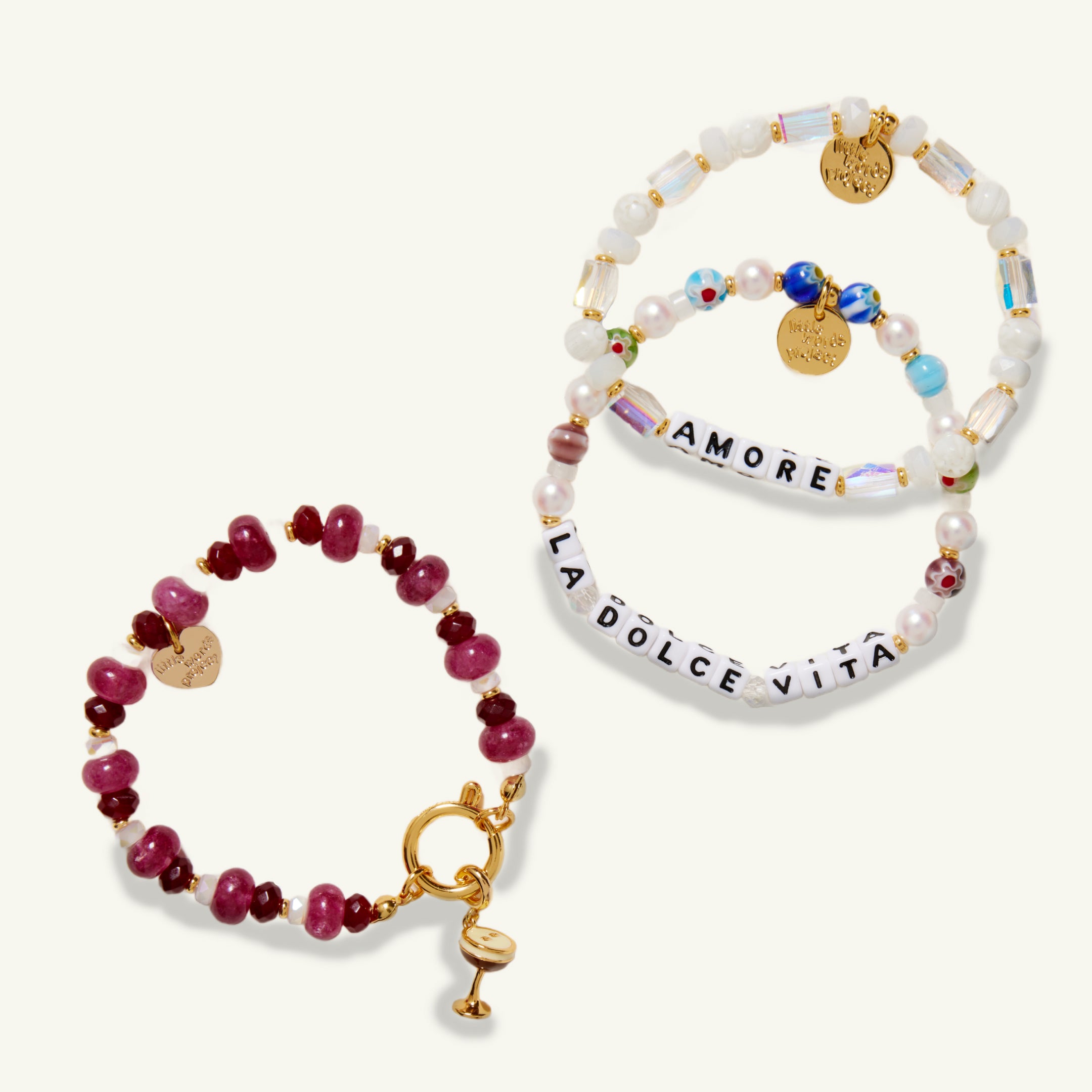 Three bracelets with colorful beads and gold accents on a white background