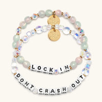 Two beaded bracelets with motivational phrases on a white background