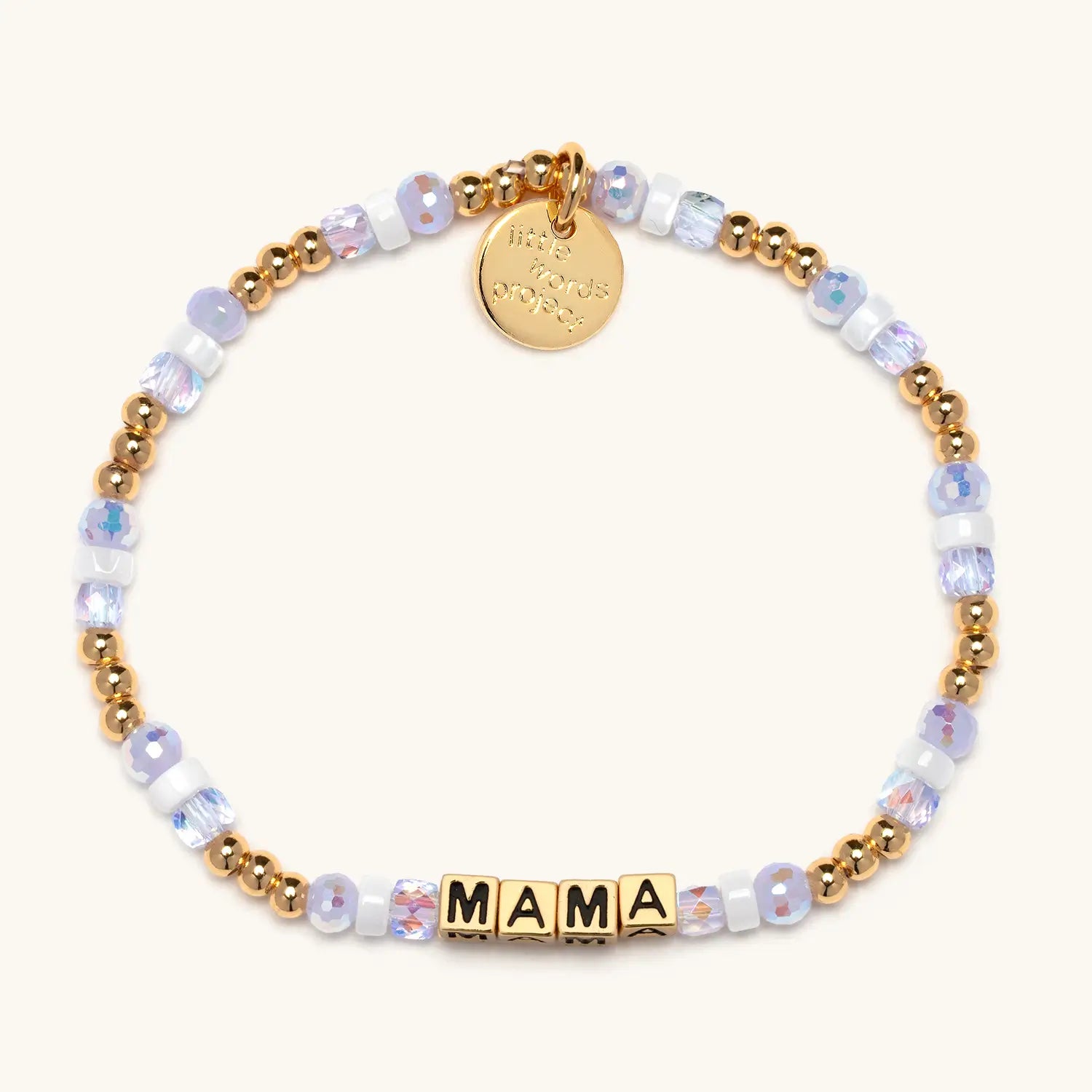 A beaded bracelet spelling MAMA in gold square letter beads with black lettering, accented with small gold round beads, iridescent white and lavender cube beads, and purple crystal beads. A small gold circular charm hangs from the top of the bracelet.