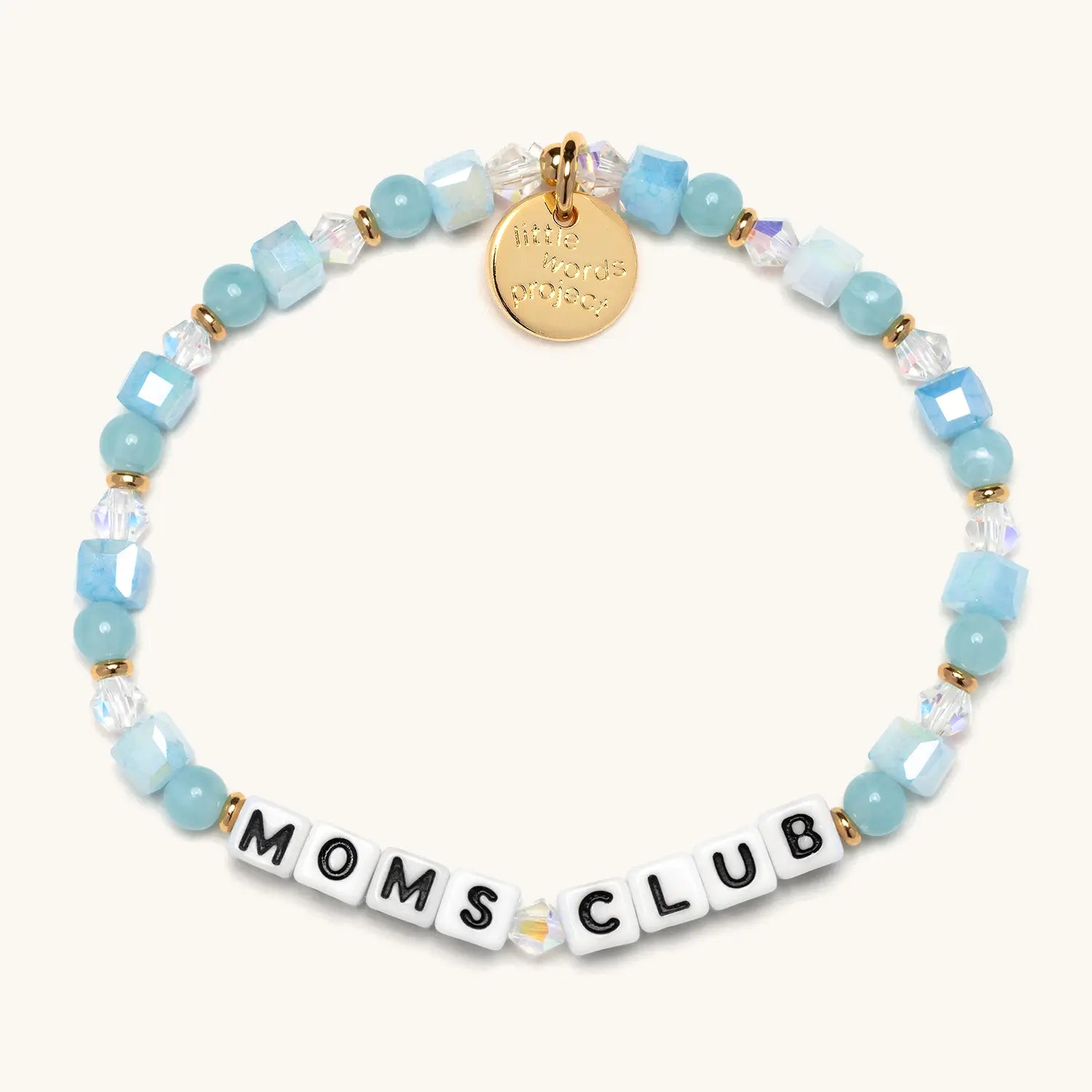 A beaded bracelet spelling "MOMS CLUB" in white square letter beads with black lettering, accented with light blue faceted cube beads, round aqua beads, clear iridescent crystal beads, and gold spacer beads. A small gold circular charm hangs from the top of the bracelet.