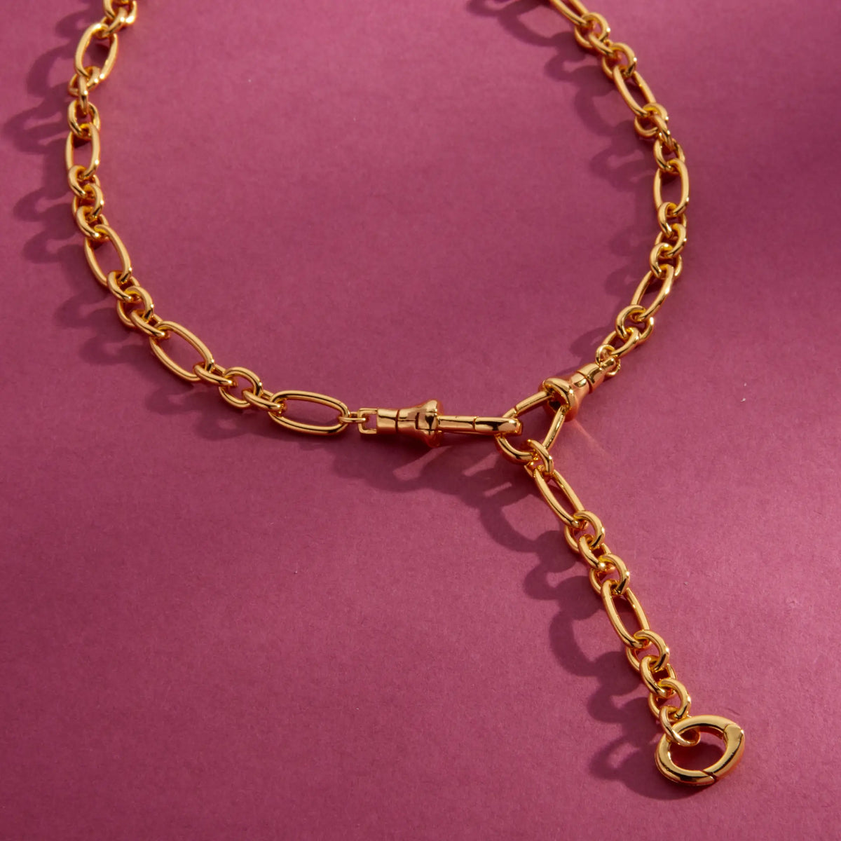 Lariat Convertible Necklace, 16k gold-plated mixed link chain lariat with a Y-drop and clasp ring for charms, detail on a berry background