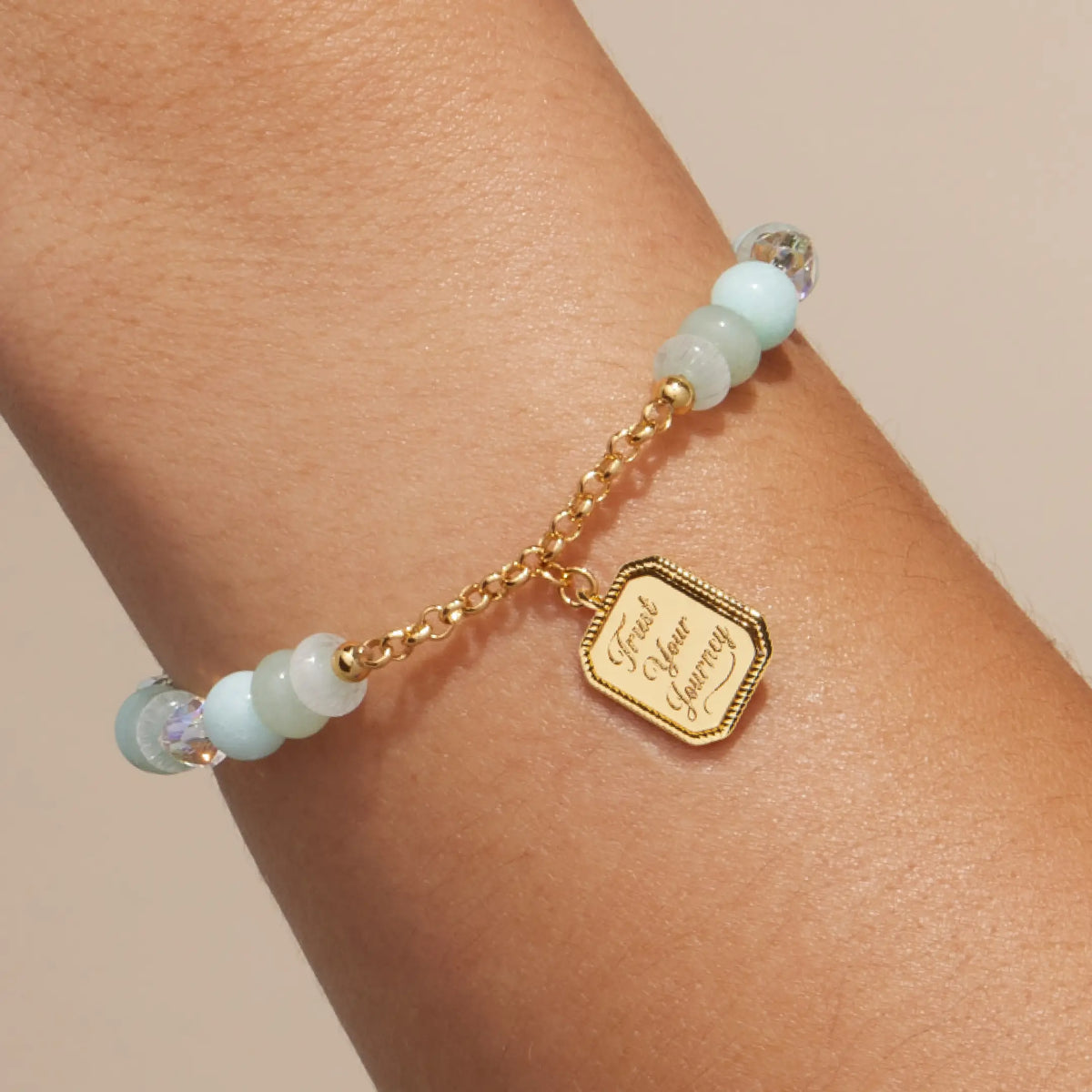 Trust Your Journey Charm Bracelet on-model, seafoam stone and clear crystal beads with gold chain and the medallion engraved Trust Your Journey