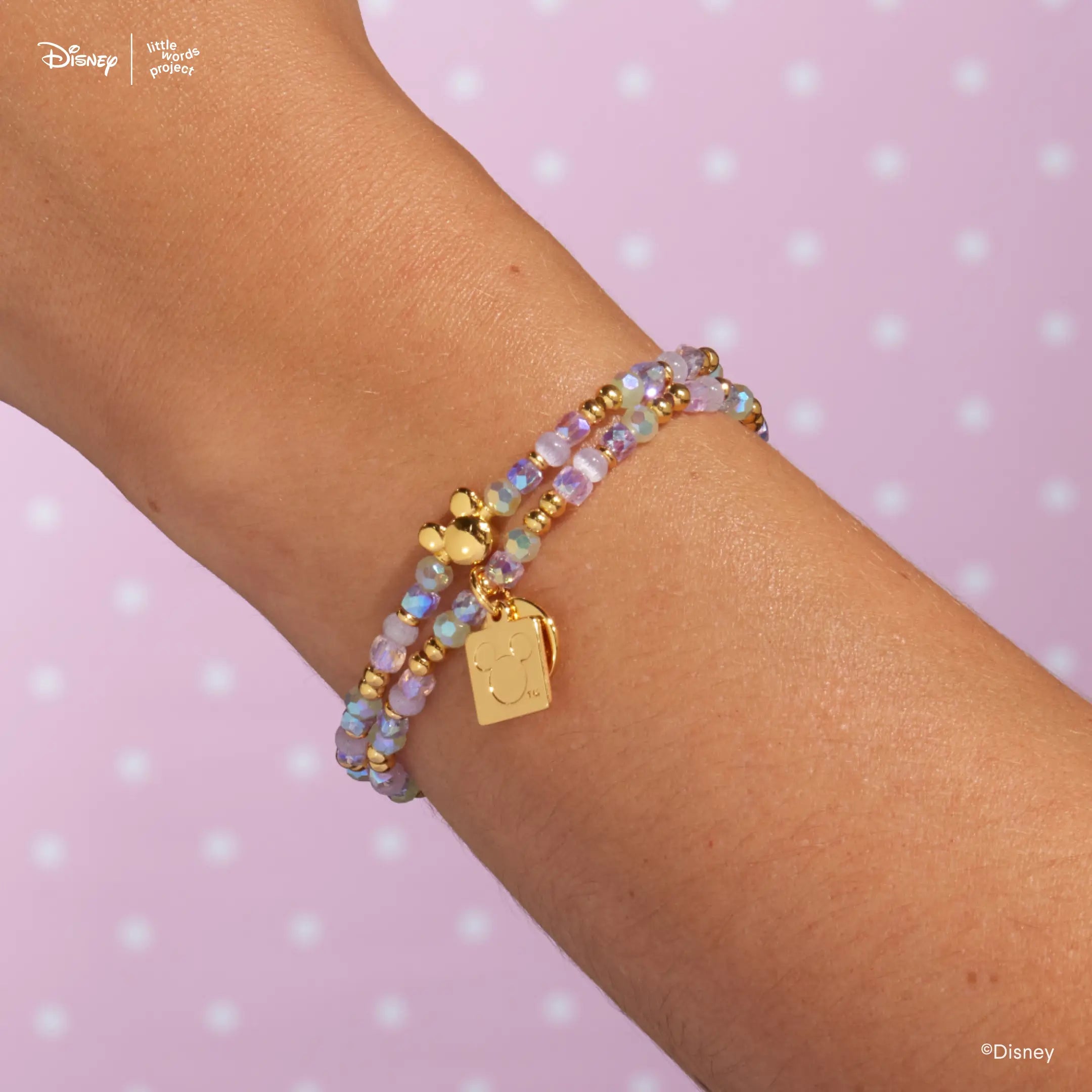 Mickey Mouse Bracelet Base from Disney Mickey and Friends worn on a wrist against a lavender backdrop, layered with a second beaded bracelet