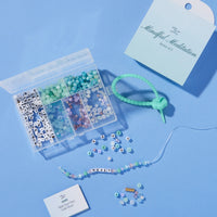 Mindful meditation bead kit against a blue background, open with a few beads scattered around the kit