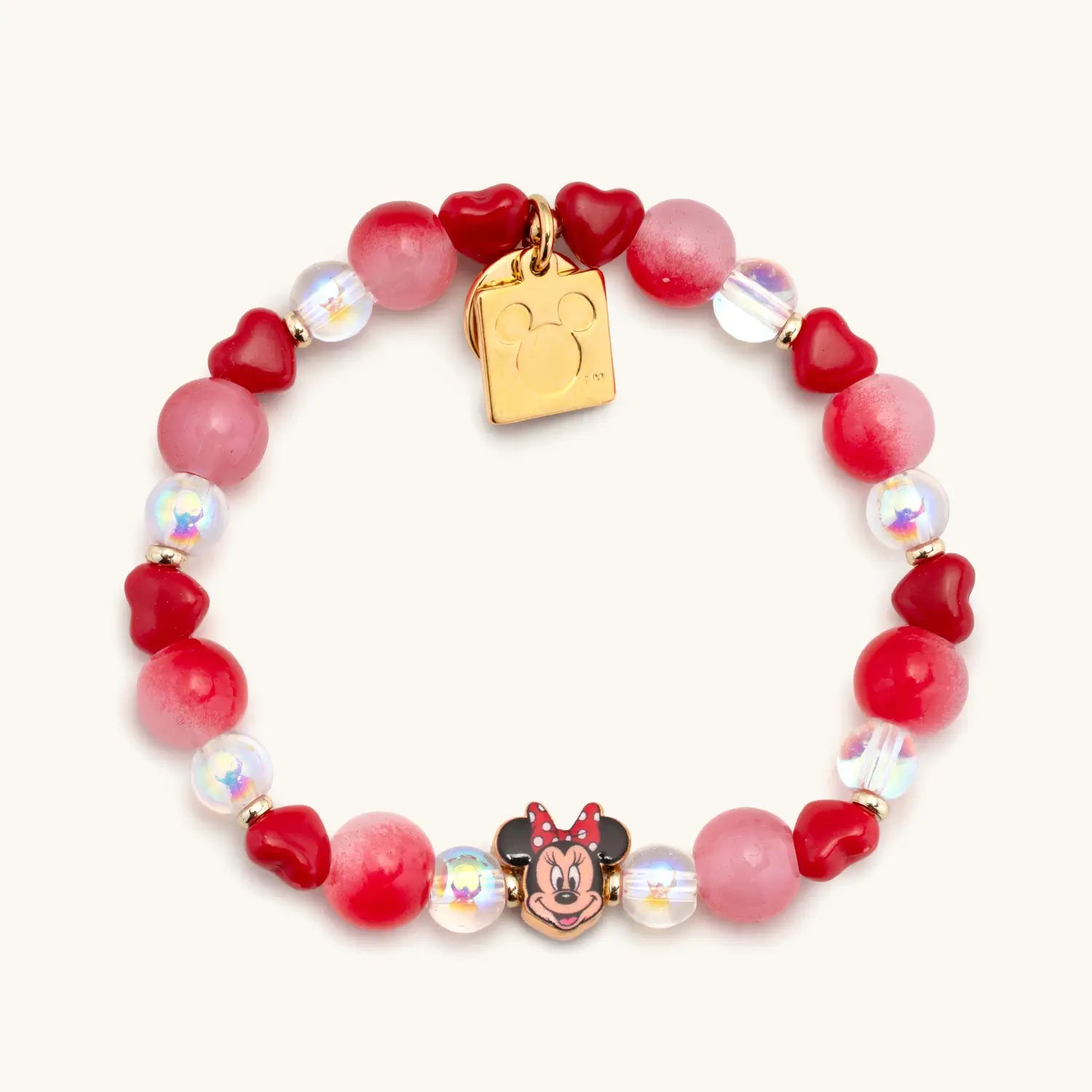 Bracelet with red and pink beads and gold tag on a white background