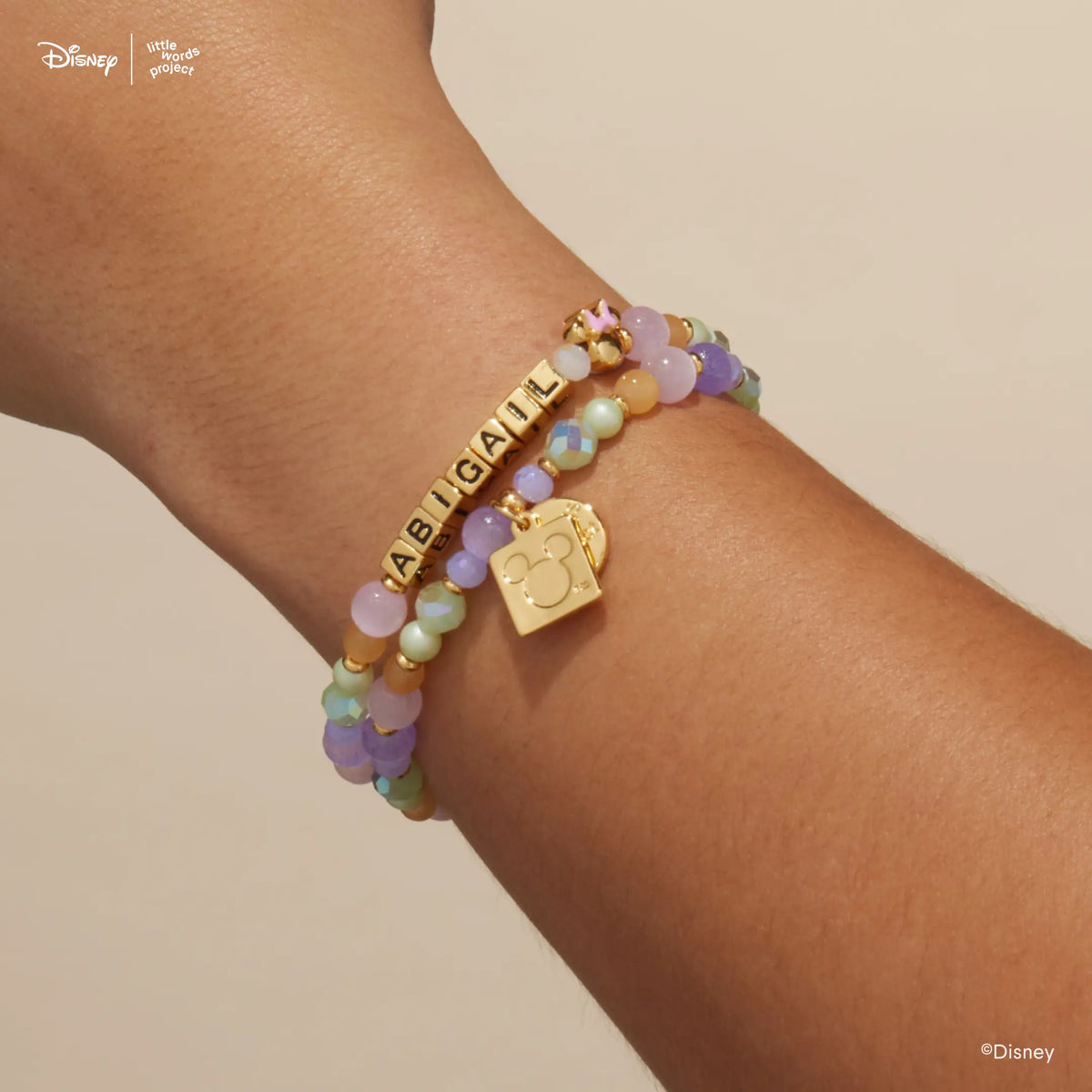 Minnie Custom Dot Darling Disney Mickey & Friends custom bracelets on wrist, gold letter bead version with pastel beads and the gold Mickey Mouse logo tag