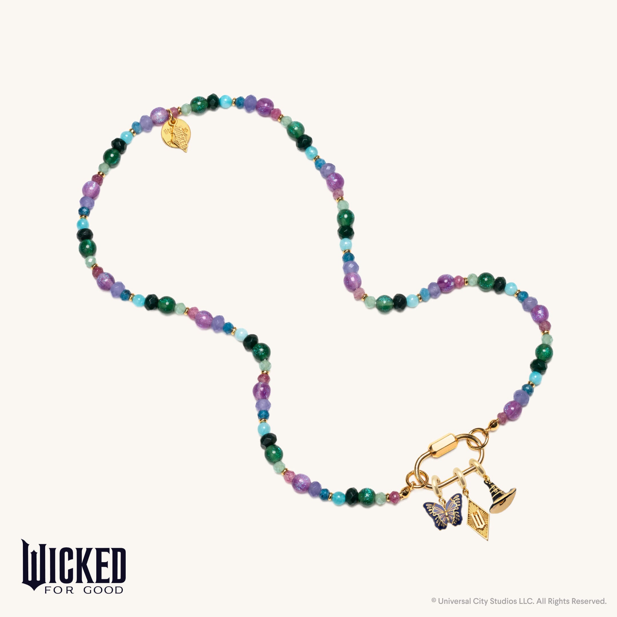 Colorful beaded necklace with gold charms on a white background, featuring the 'Wicked for Good' brand.