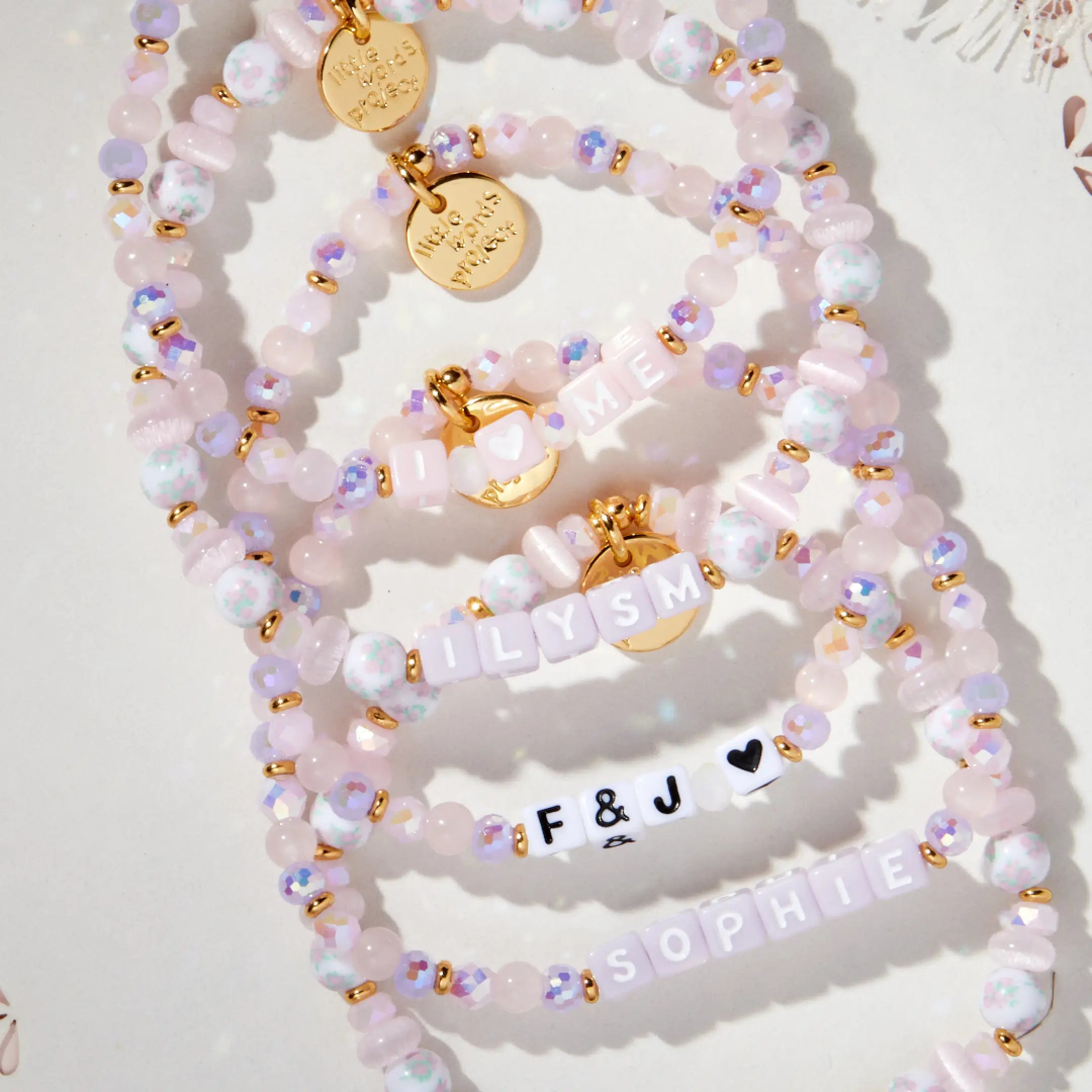 Set of beaded bracelets with gold accents and charms on a white background