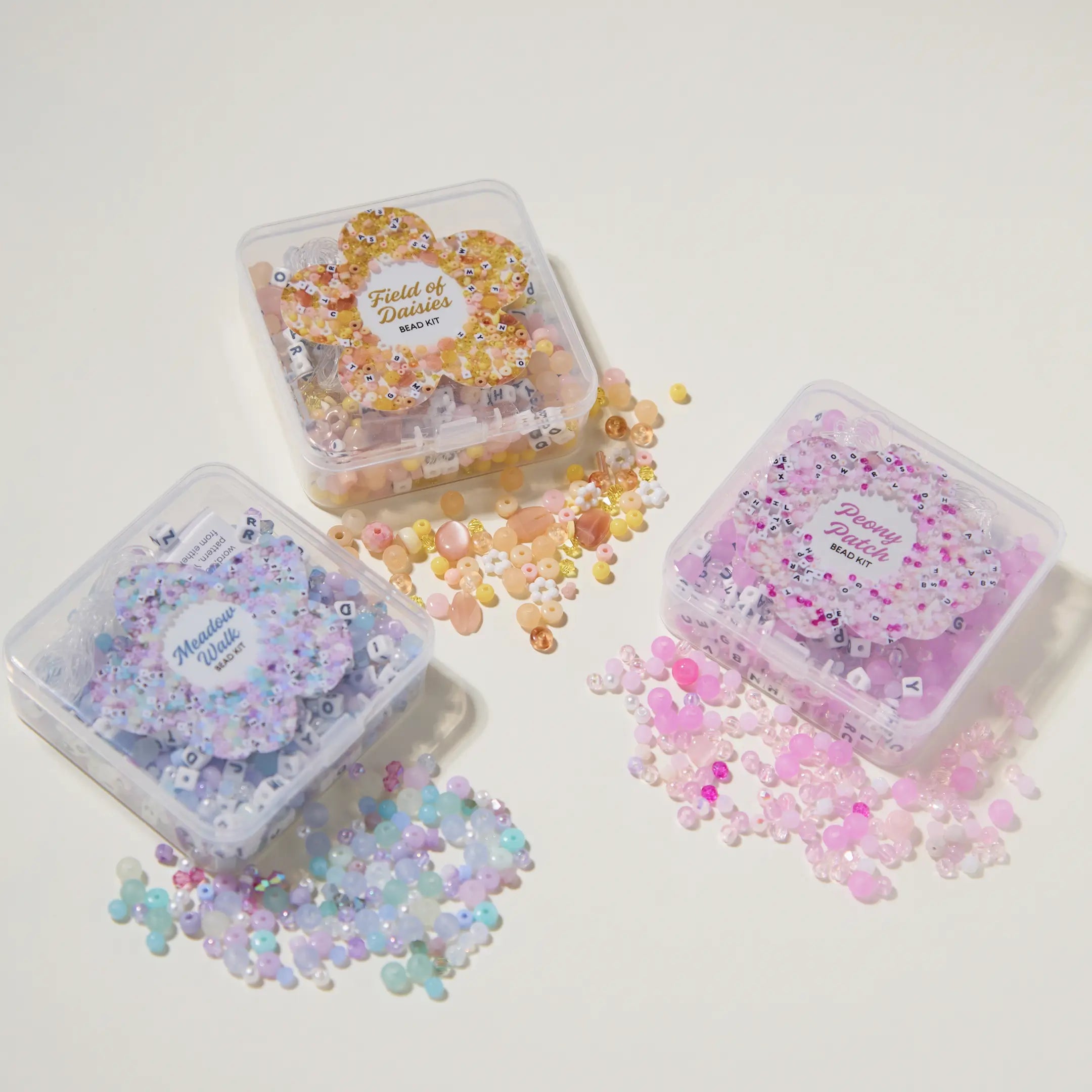 Three small transparent containers filled with colorful decorative items on a white background