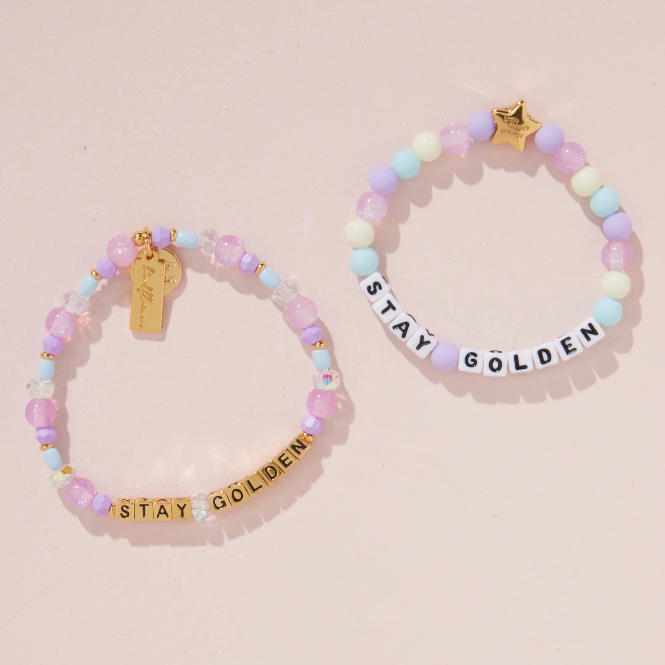 Stay Golden Bracelet Set Rylee Ta adult bracelet with gold letter beads and kids bracelet with white letter beads styled together on a blush pink background