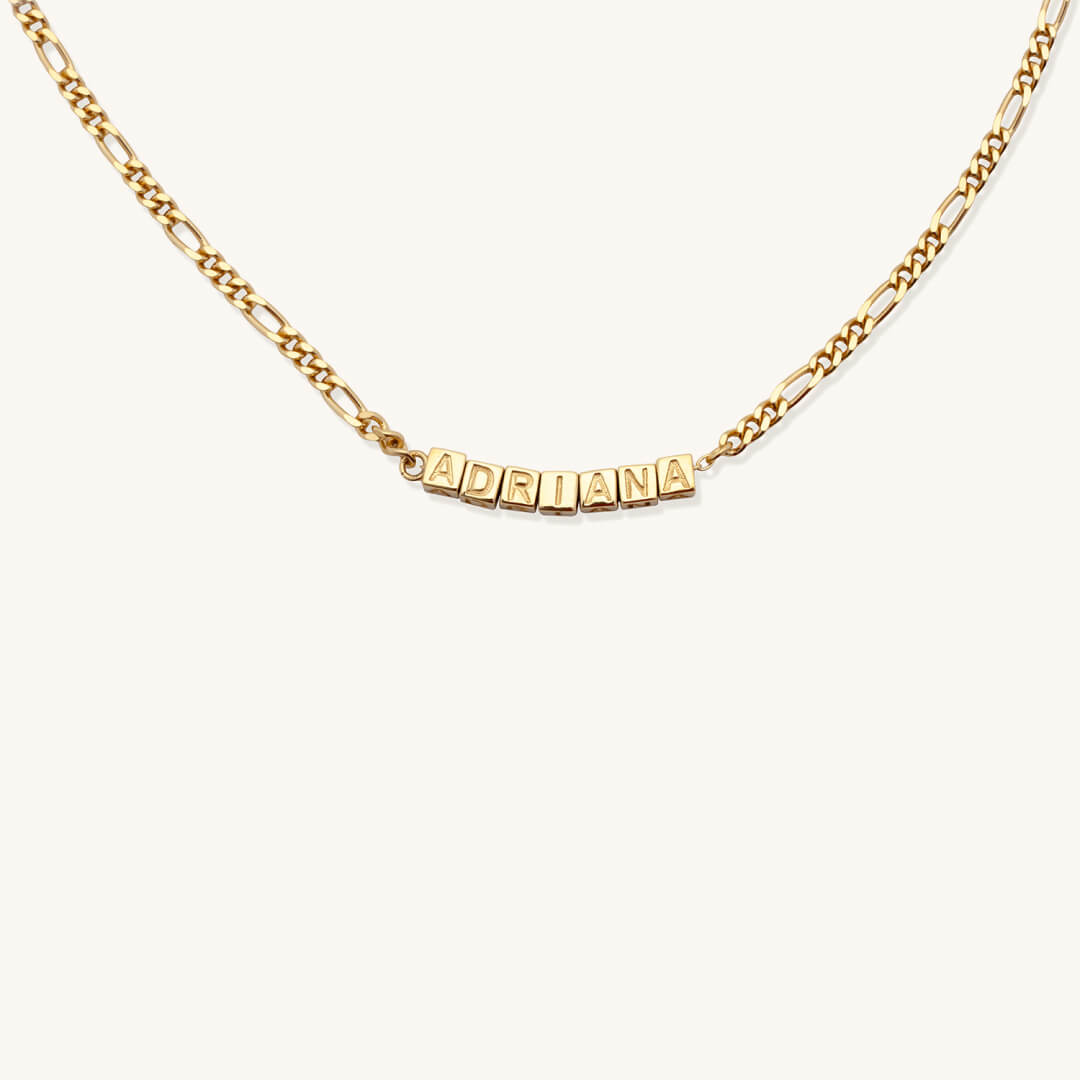Gold necklace with 'ADRIANA' pendant on a white background