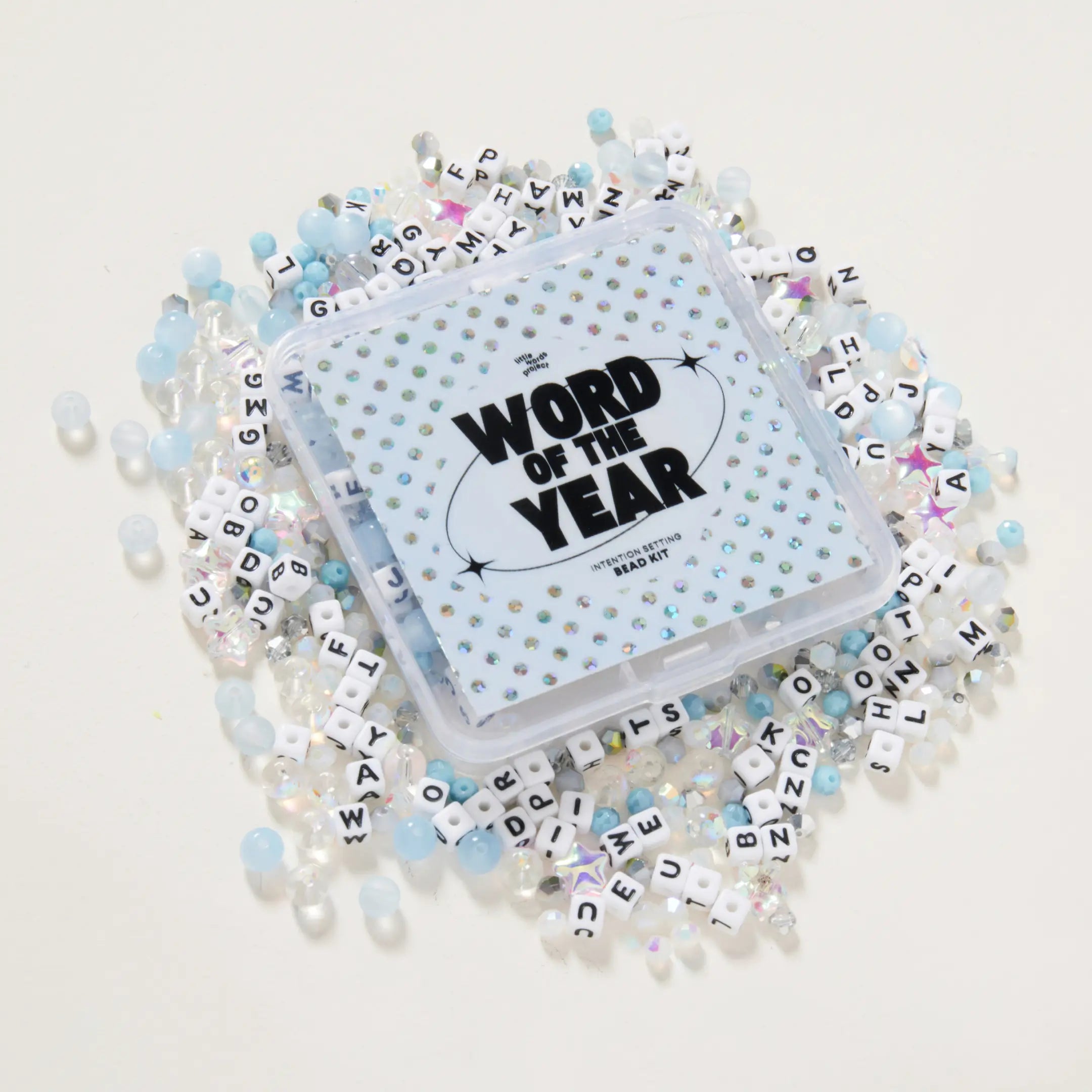 Packaged product with 'Word of the Year' text surrounded by letters and beads on a light background