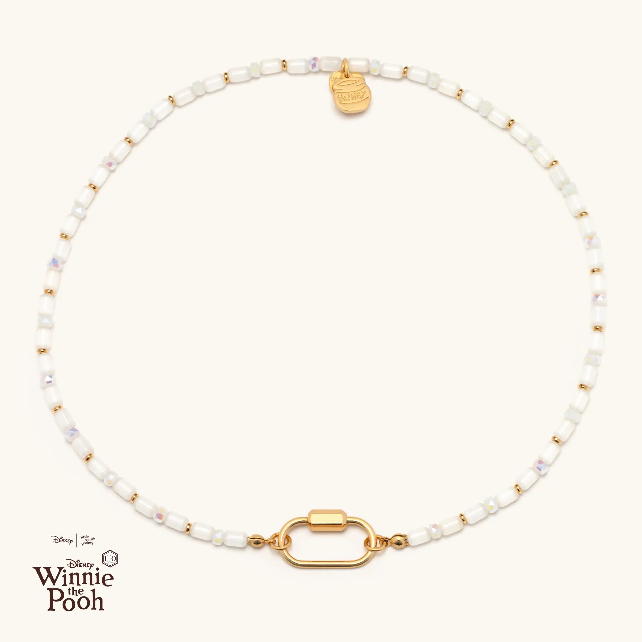 Necklace with gold and white beads on a white background, featuring Disney Winnie the Pooh logo.