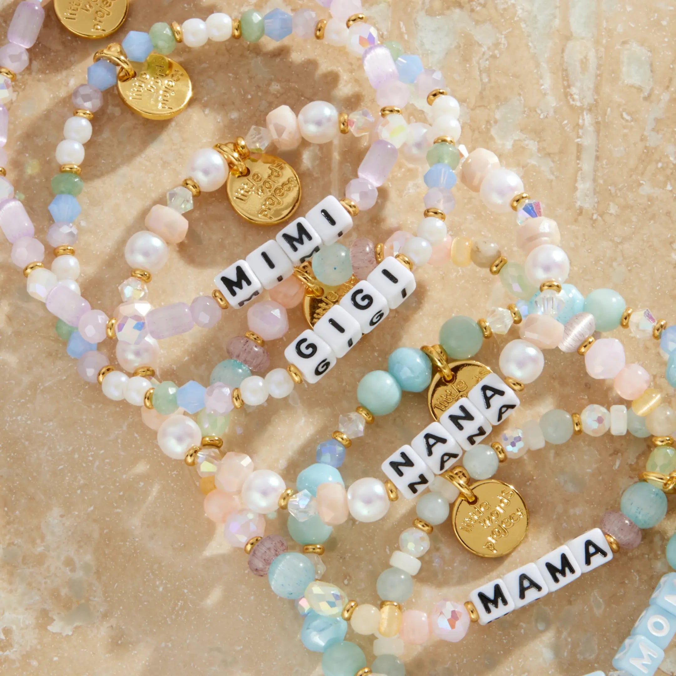Set of beaded bracelets with charms on a textured beige surface