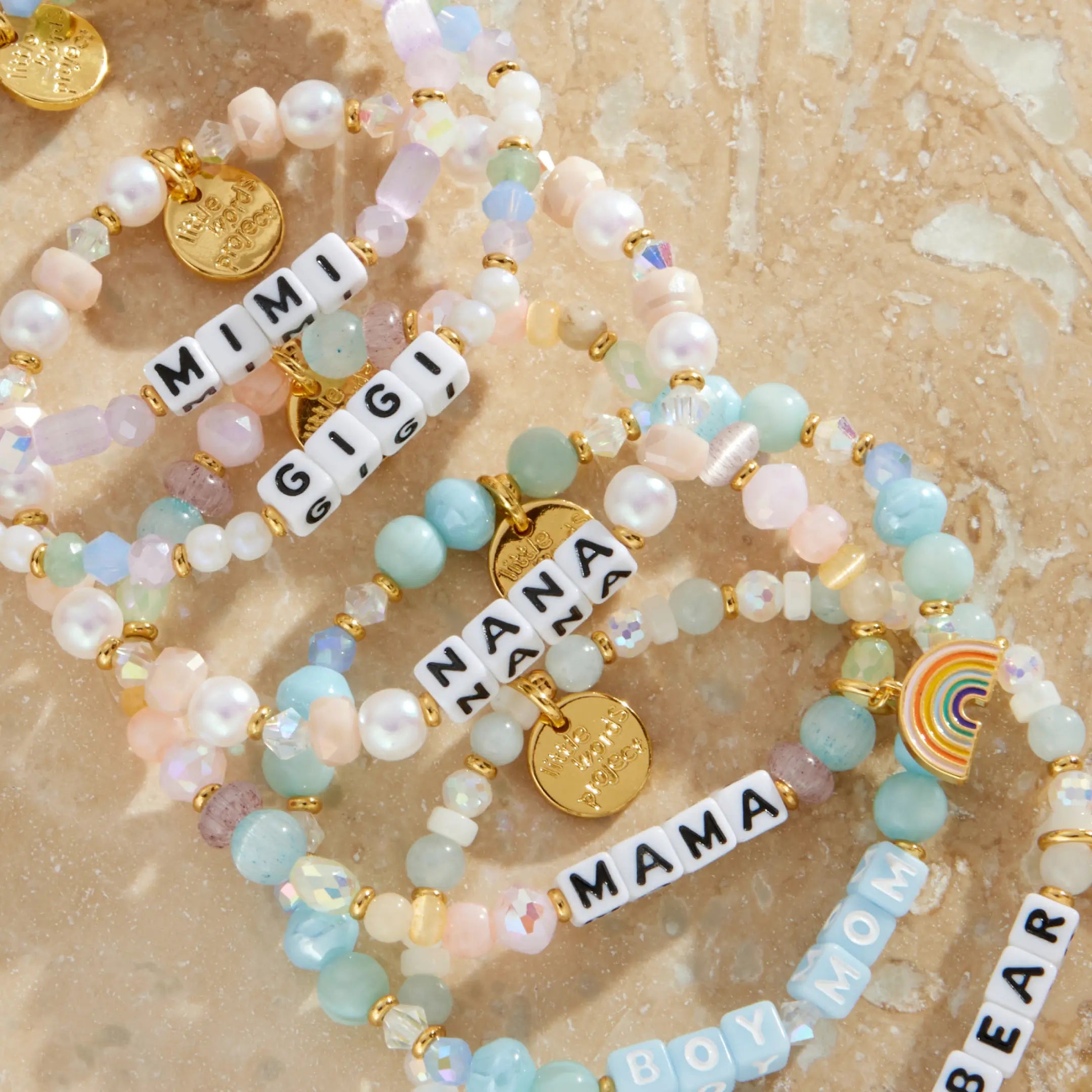 Set of beaded bracelets with charms on a beige marble background