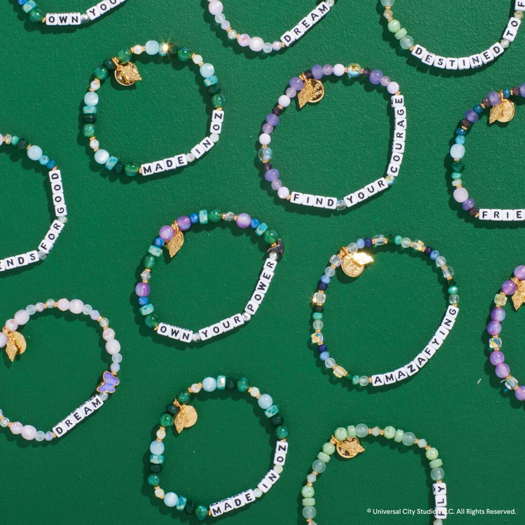 Beaded bracelets with motivational phrases on a green background