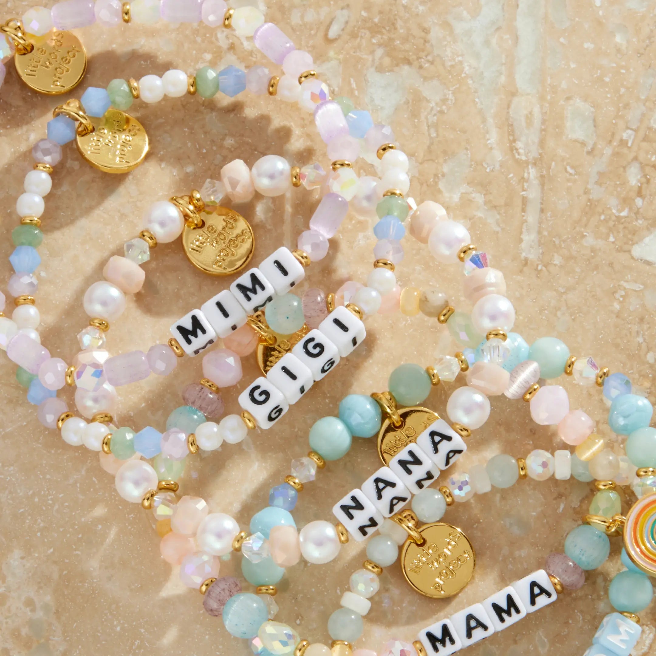 Set of beaded bracelets with charms on a textured beige surface