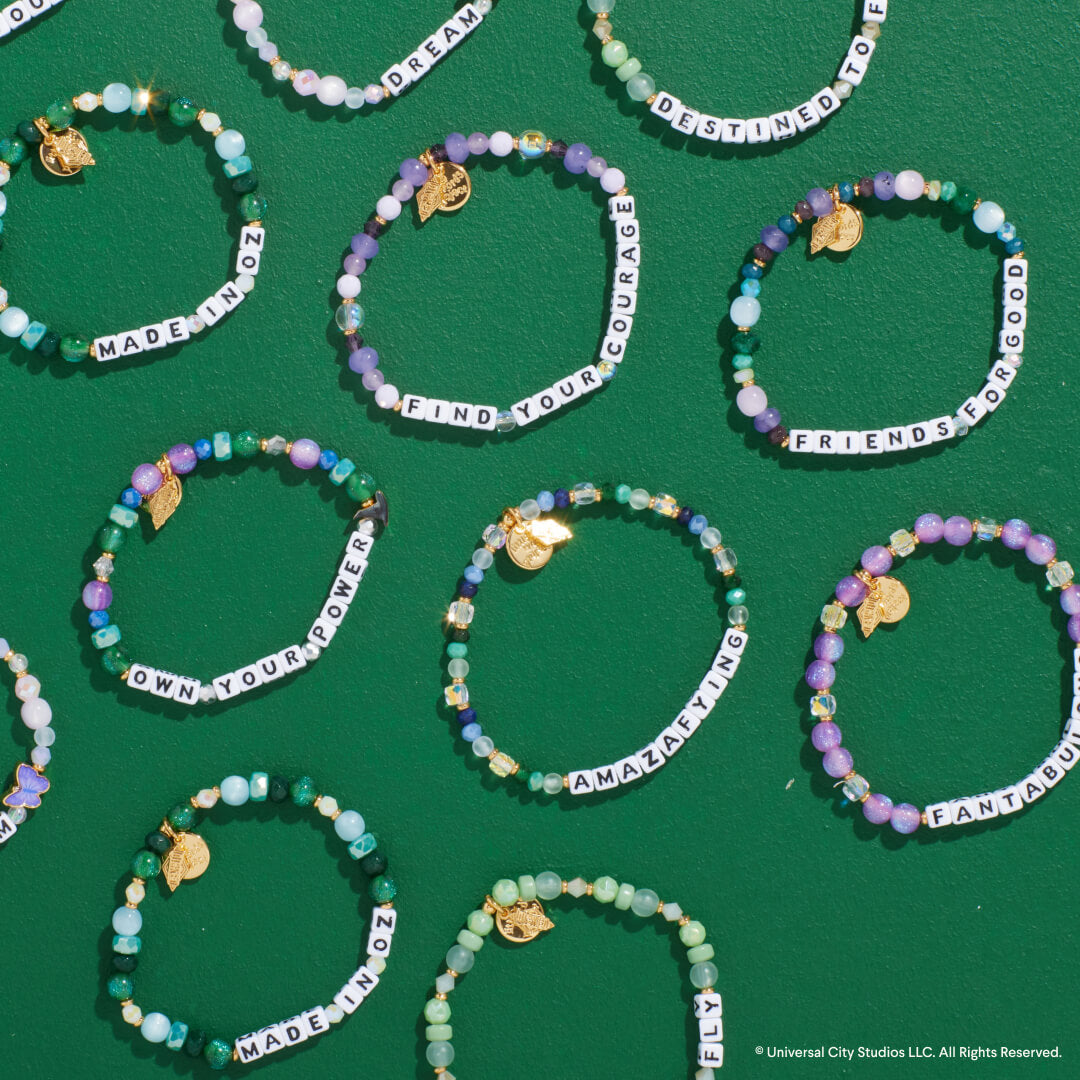 Beaded bracelets with motivational phrases on a green background