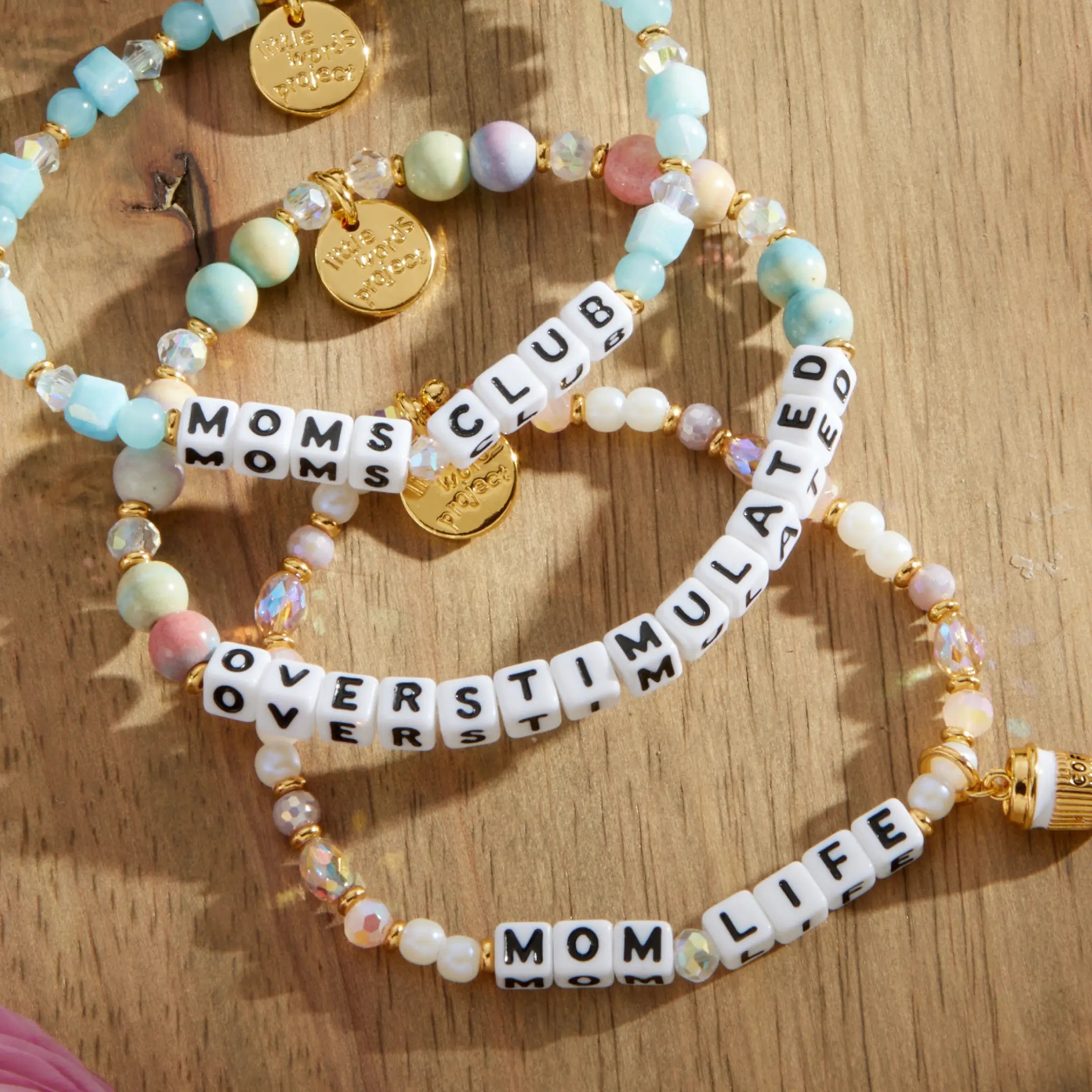 Set of beaded bracelets with text on a wooden surface