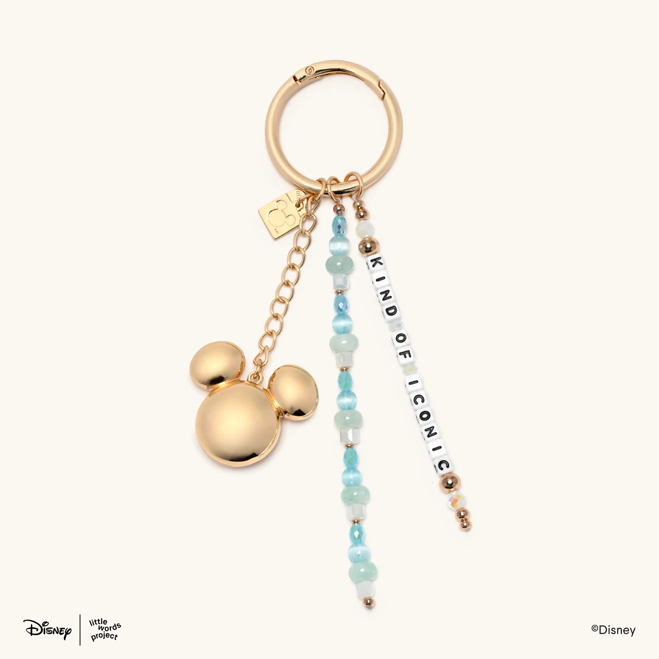 Kind of Iconic Bag Charm from Disney Mickey and Friends on cream, gold plated ring with a Mickey Mouse head charm, blue beaded strands and Kind Of Iconic letter beads