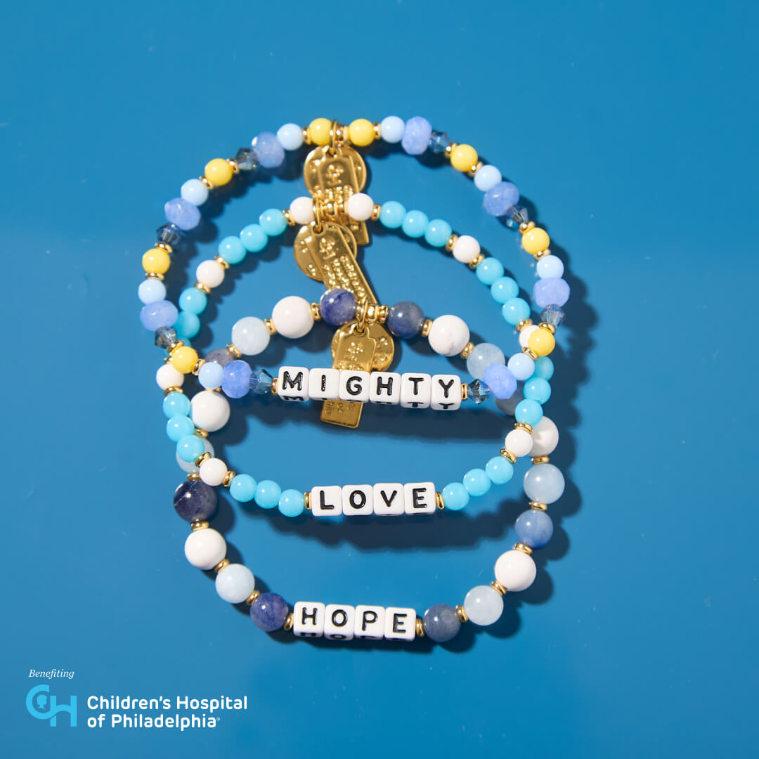 Stack of colorful beaded bracelets with inspirational words on a blue background, benefiting Children's Hospital of Philadelphia.