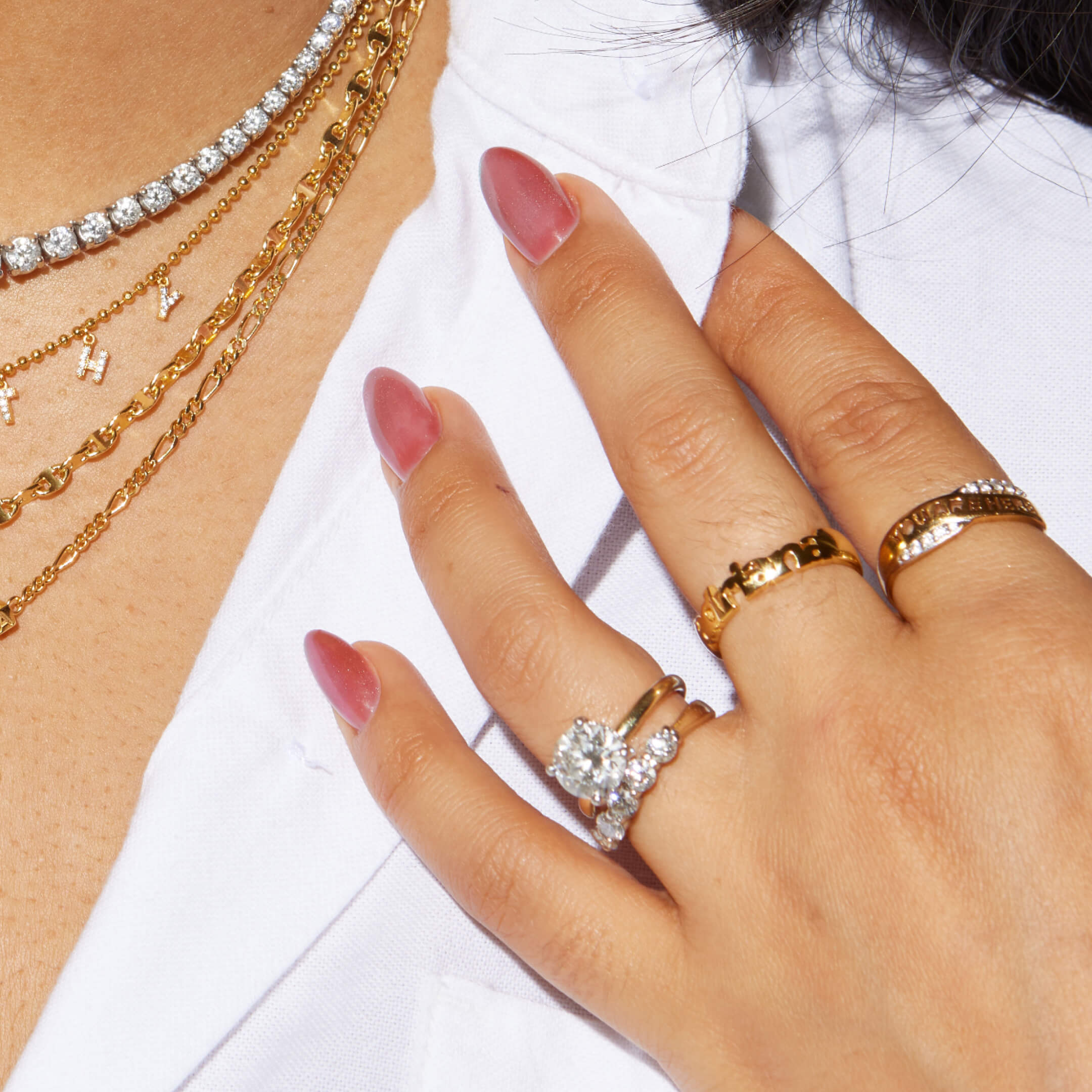 Hand wearing gold rings with a white background