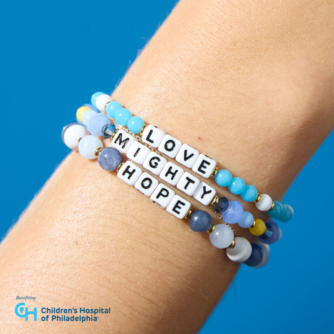 Bracelets with motivational words on a wrist against a blue background, featuring the Children's Hospital of Philadelphia logo.